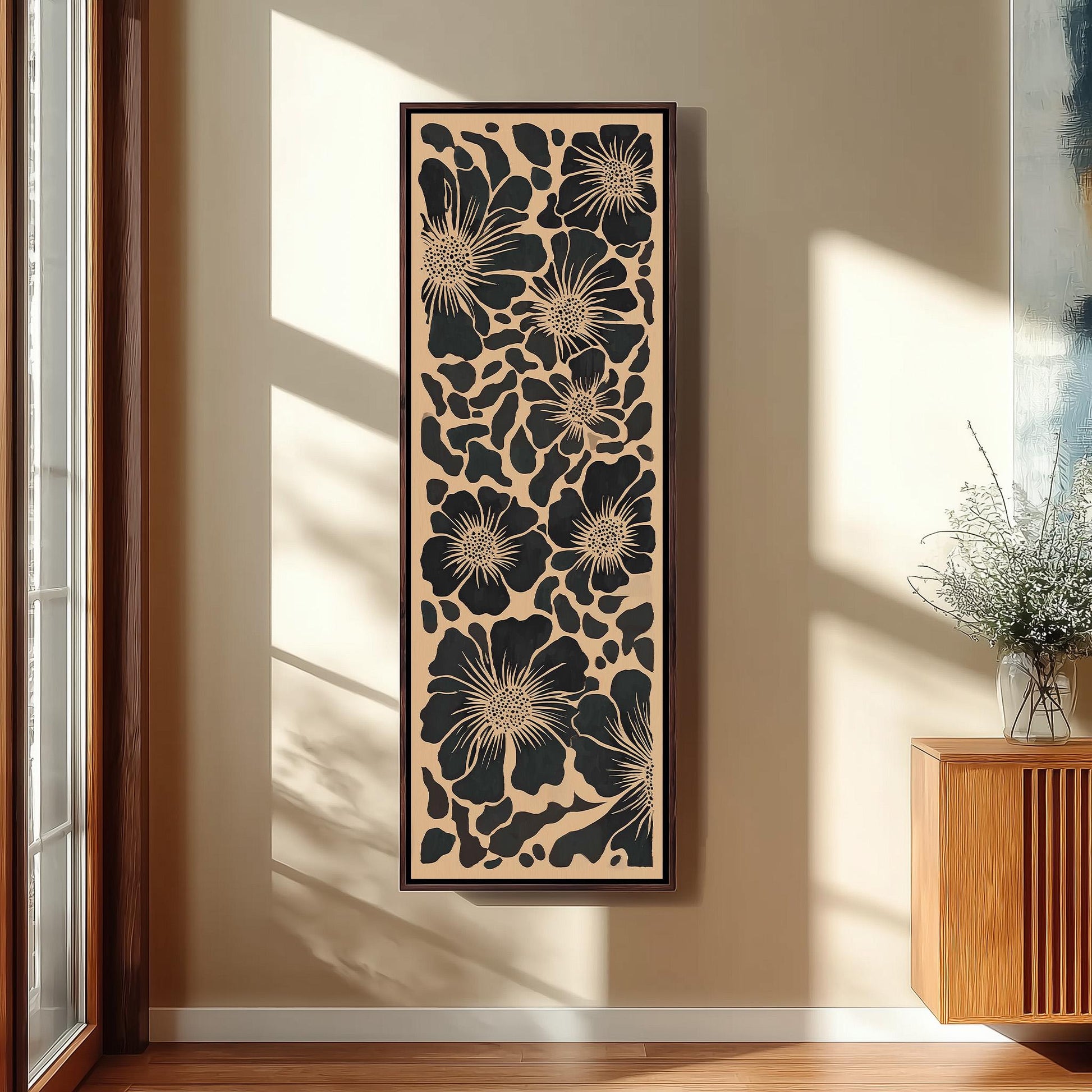 a large framed artwork with a floral pattern hanging on a wall in a room with a wooden floor and a window.
