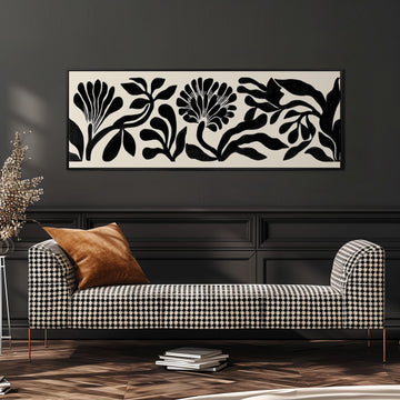 a black and white checkered sofa with a brown throw pillow, set against a dark wall with a large black and white abstract floral artwork hanging above it.