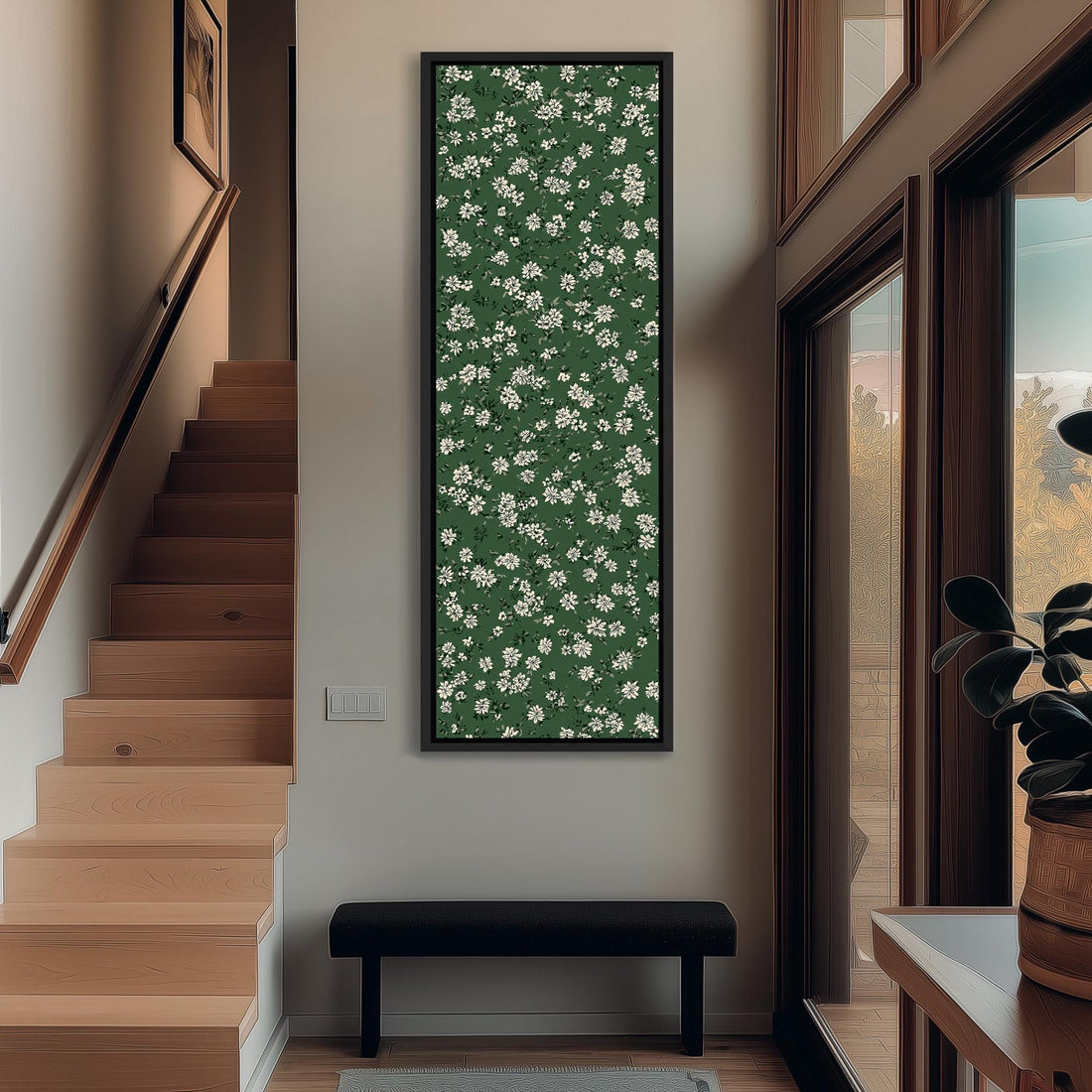 a large framed picture hanging on a wall, with a green floral pattern covering the entire frame. The picture is placed next to a wooden cabinet and a vase of flowers, creating a cozy and inviting atmosphere in the room.