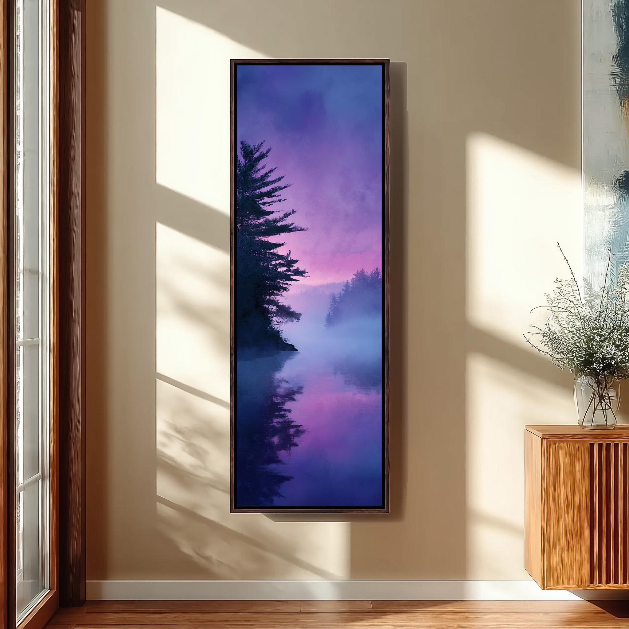 a large framed painting hanging on a wall, depicting a serene landscape with a body of water and a misty, purple-hued sky.