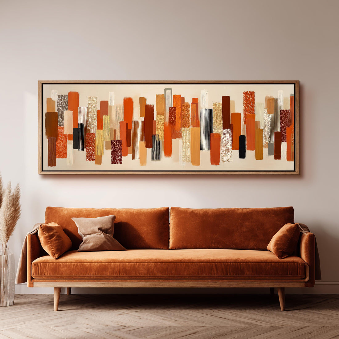 a large abstract painting hanging on a wall above a brown sofa with two pillows.