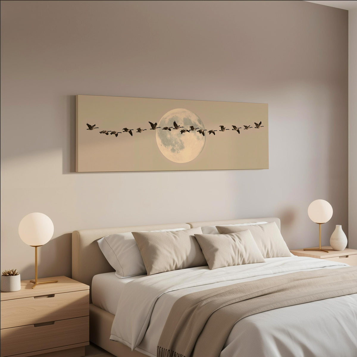 Geese flying across a pale moon on sand wide panoramic canvas print above a bed in a neutral bedroom