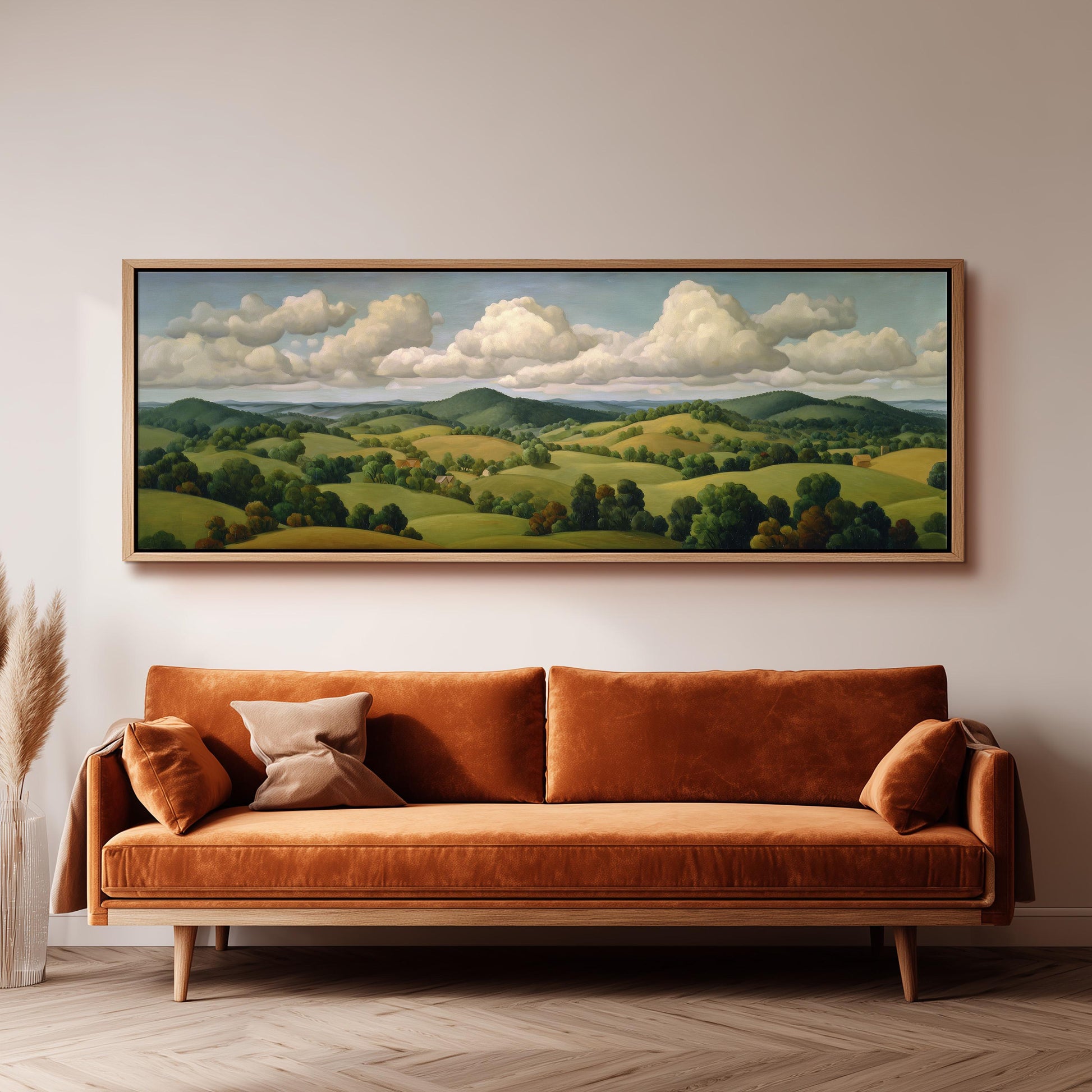 a large landscape painting hanging on a wall above a brown sofa with two pillows.