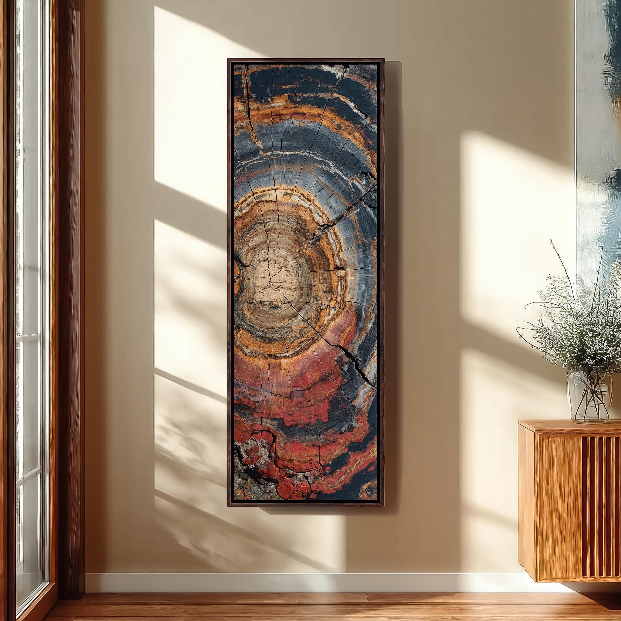 a large, colorful abstract painting hanging on a wall in a room with a wooden cabinet and a vase of flowers.