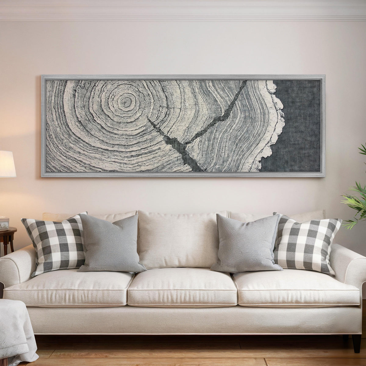 Grey tree ring on linen texture panoramic canvas print above a white sofa in a bright living room