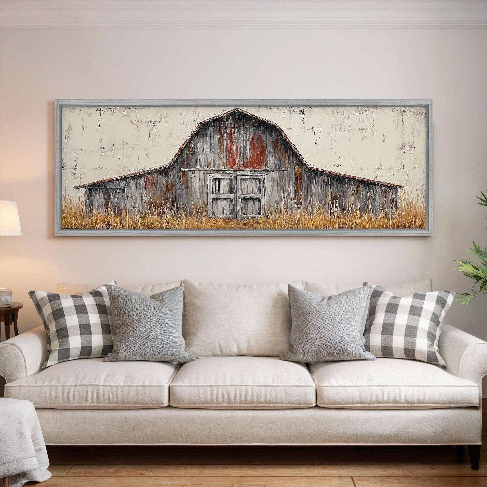 a large, rustic barn painted on a wall above a white couch with gray and white plaid throw pillows.