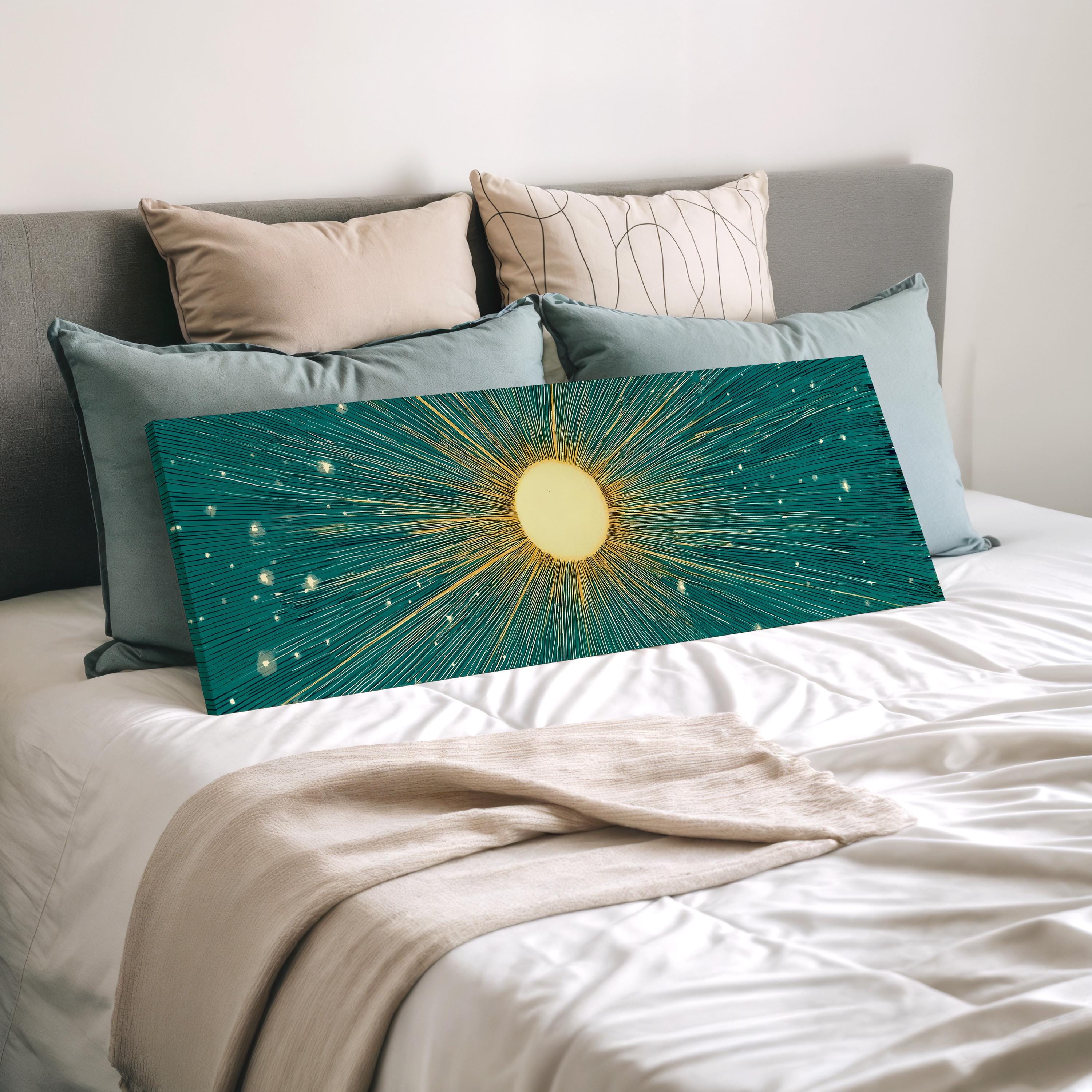 a bed with a large, colorful canvas print featuring a sun-like design in shades of blue and green, resting on a white bedspread.