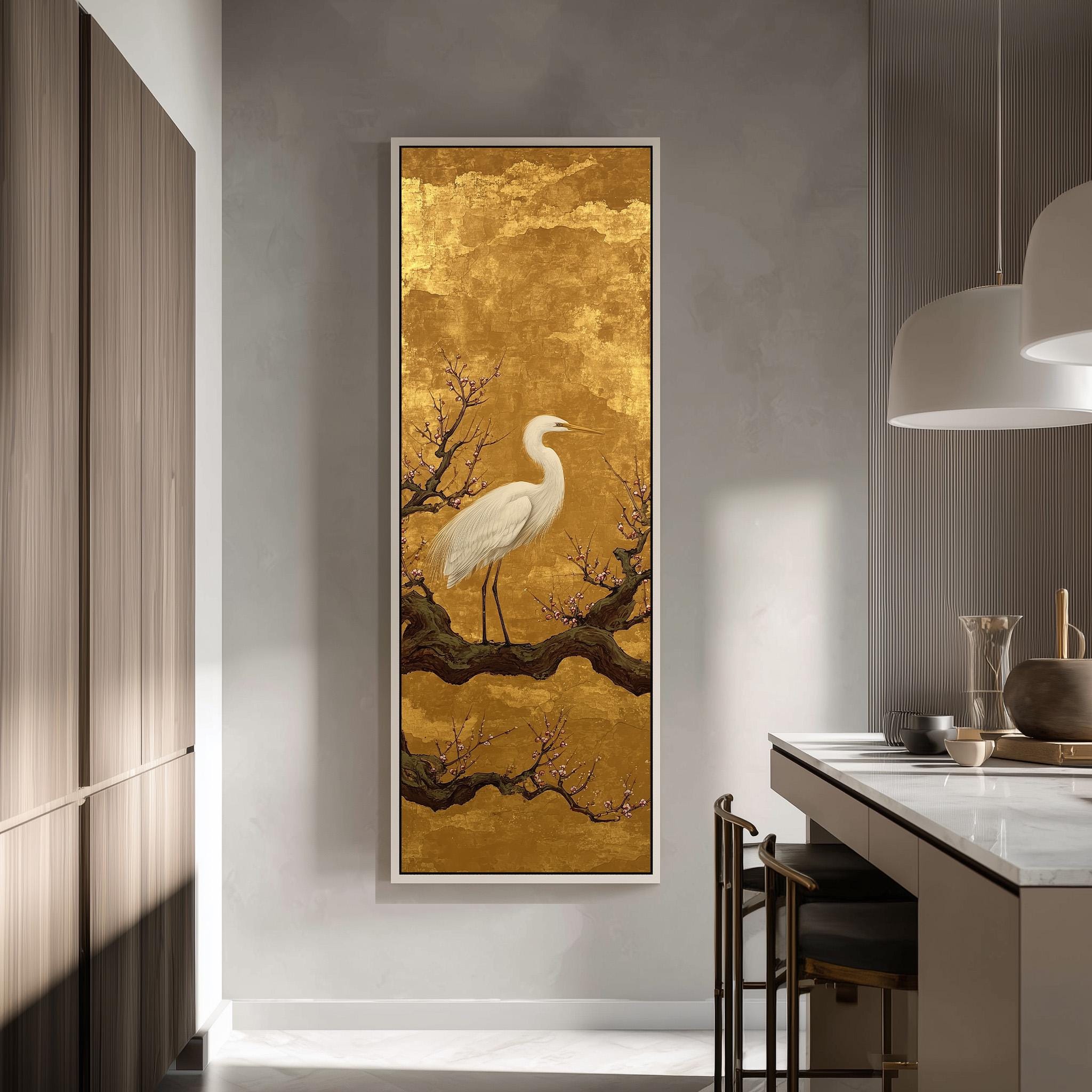 a large, framed painting of a white crane standing on a branch with flowers, hanging on a wall in a modern kitchen.