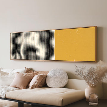 Black wavy stripes beside a mustard block long horizontal canvas print above a sofa in a living room