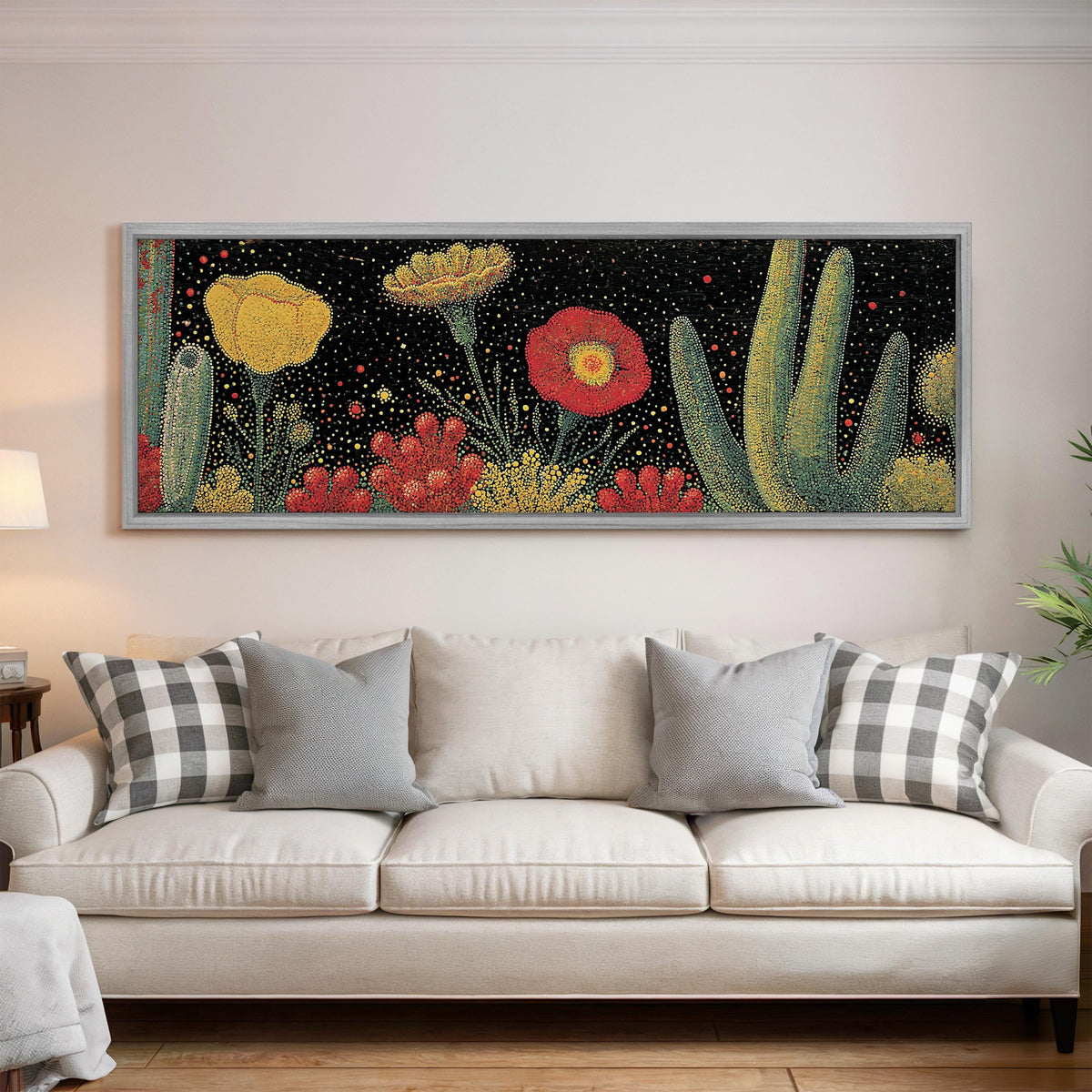 Desert blooms and cacti on black panoramic canvas print above a white sofa in a bright living room