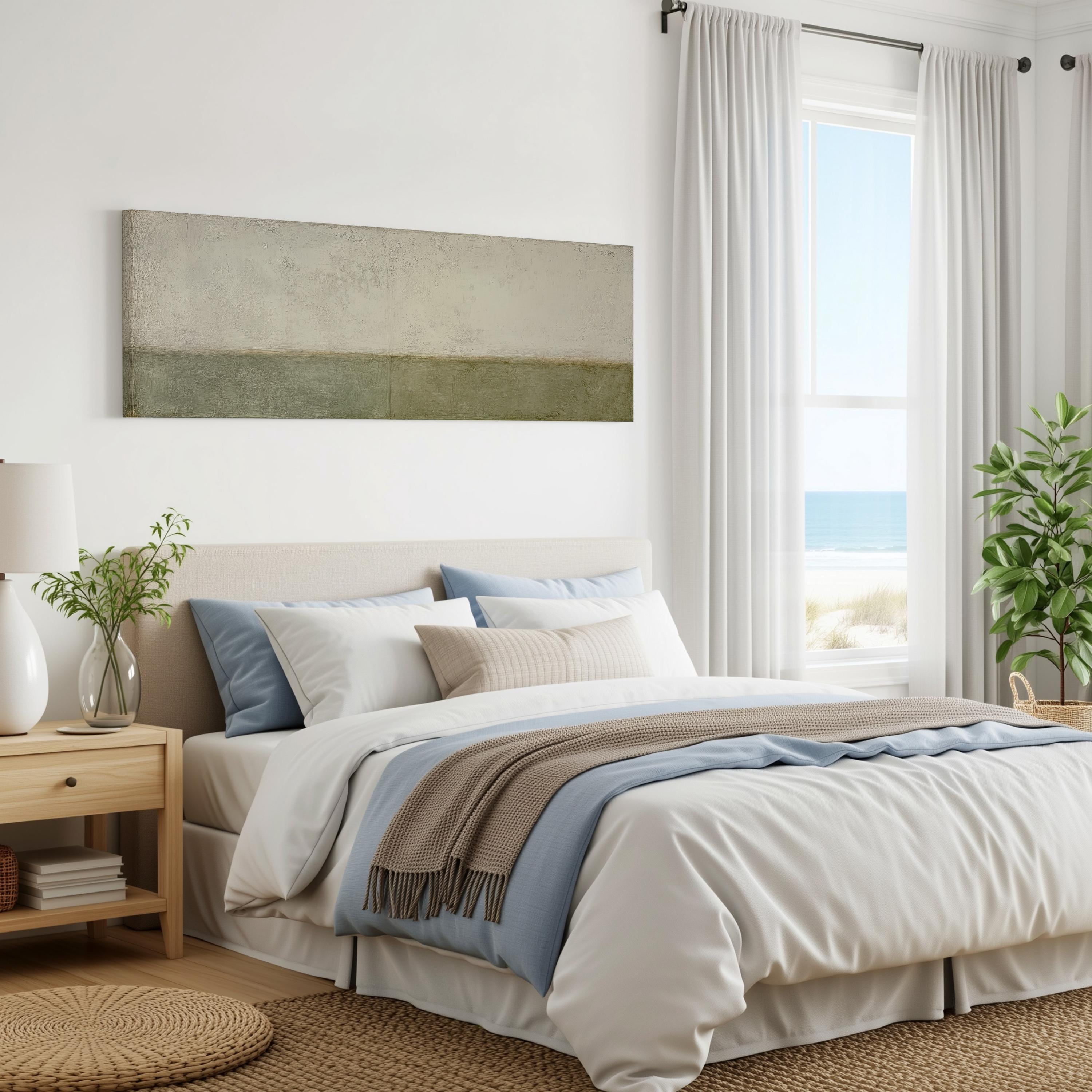 a serene and modern bedroom with a large bed, a nightstand, and a painting on the wall. The room has a neutral color palette with white walls, a beige bedspread, and a blue throw blanket. The window offers a view of the ocean, creating a calming and relaxing atmosphere.