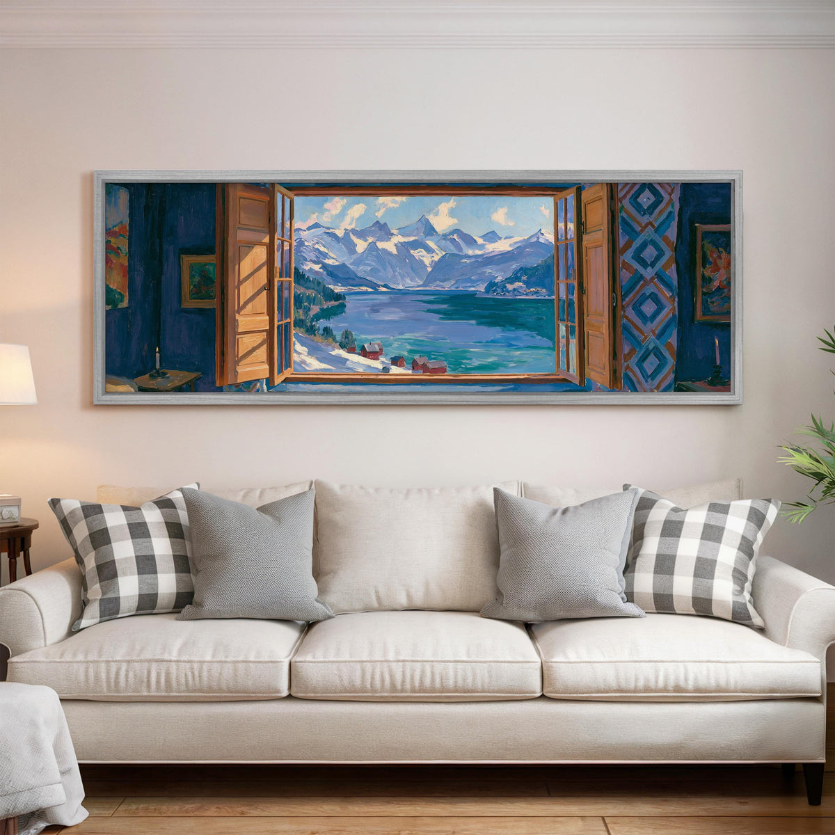 Snowy alpine lake seen through a window panoramic canvas print above a white sofa in a bright living room