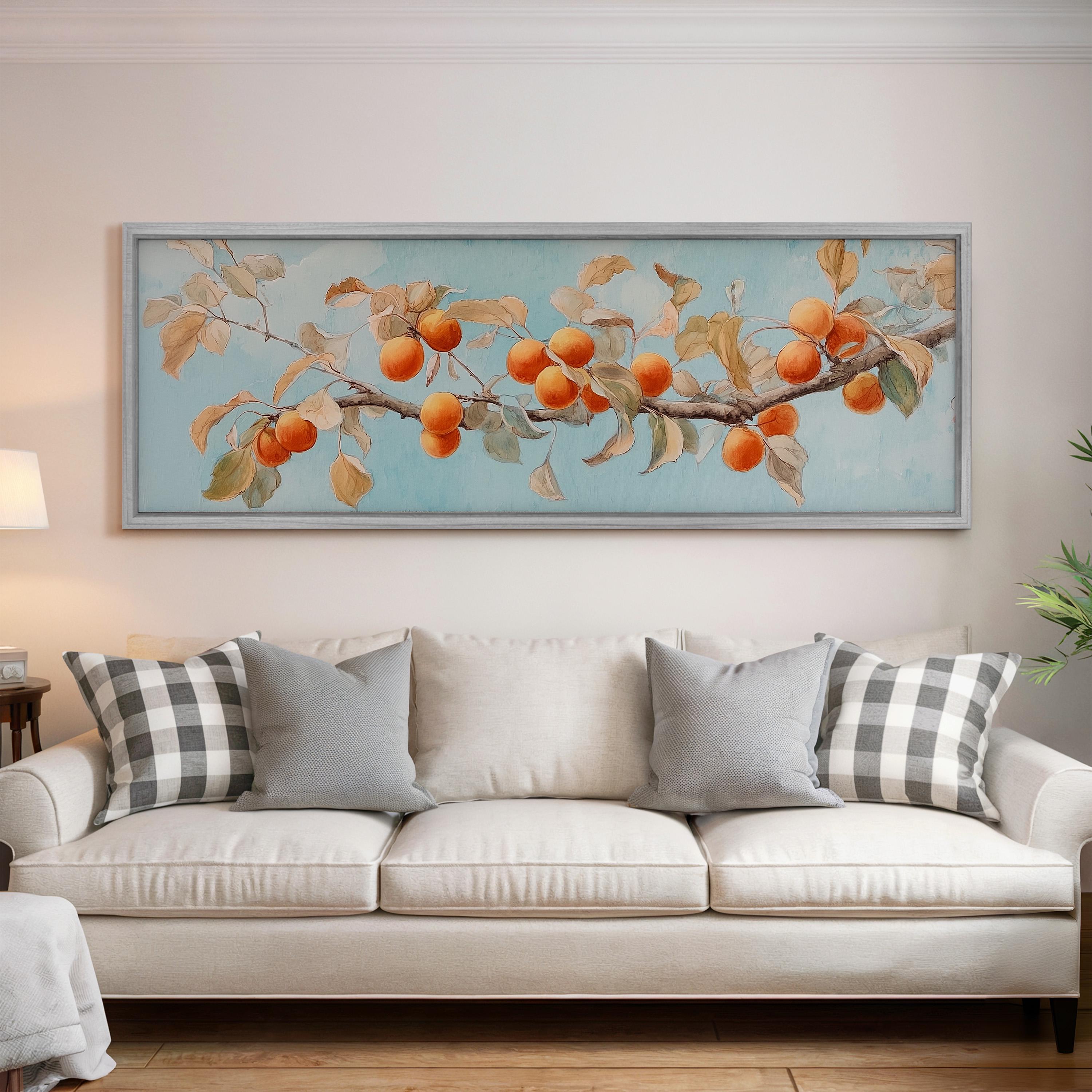 a large framed painting of a branch with orange fruits hanging on the wall above a white couch with gray and white plaid throw pillows.