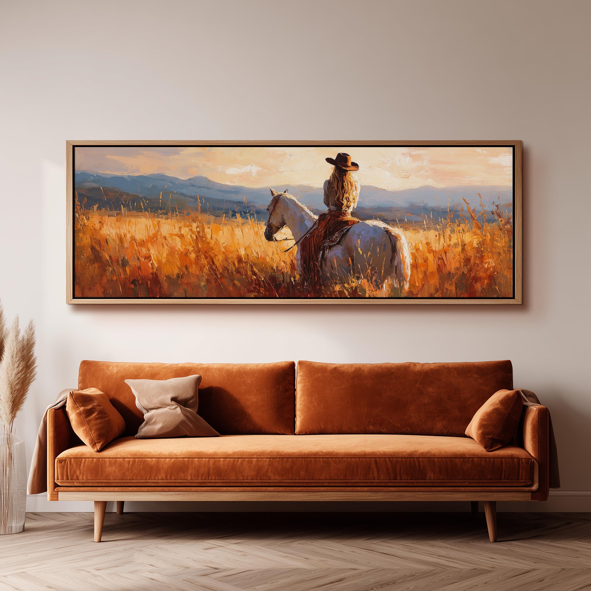 a large painting of a woman riding a horse in a field, with mountains in the background.