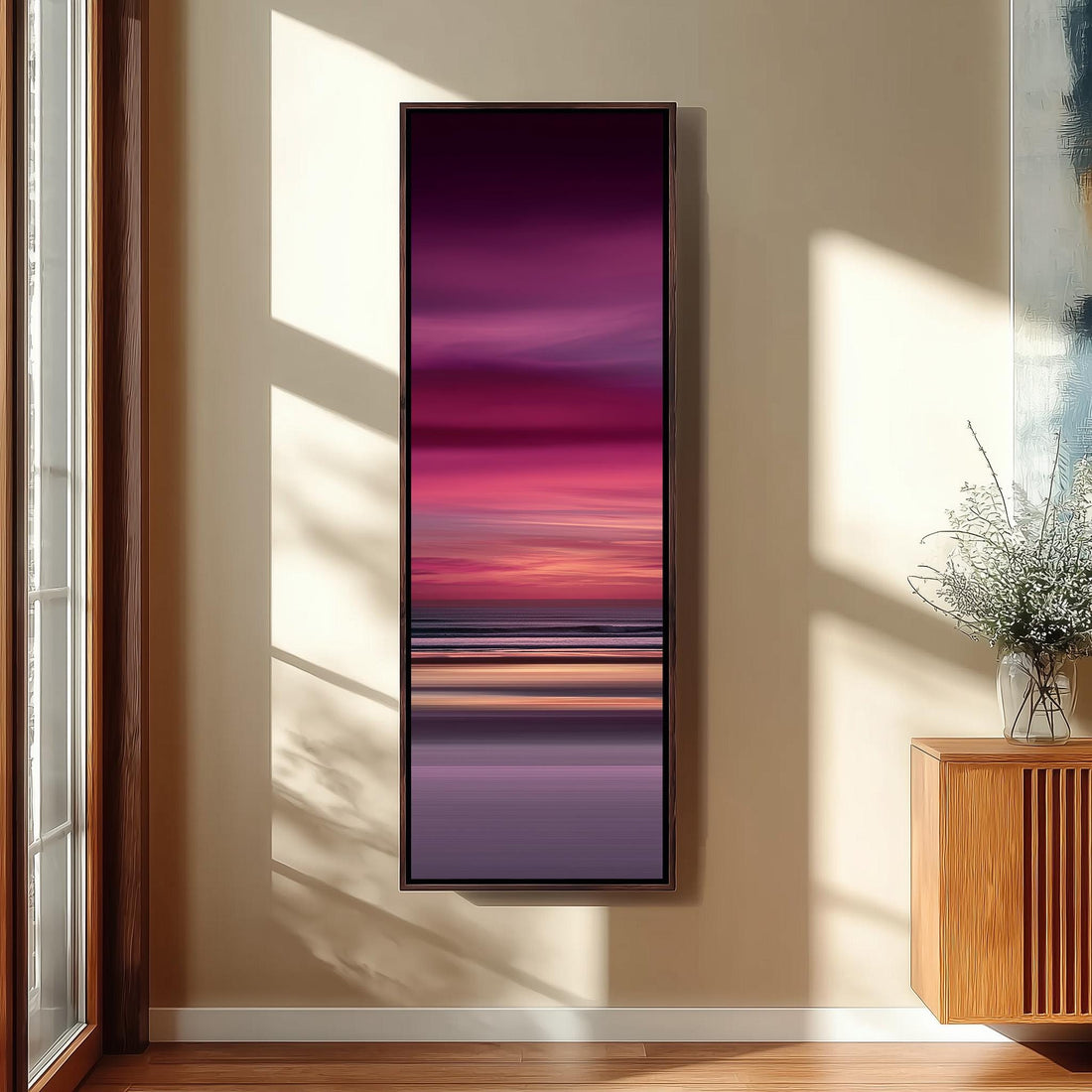 a modern interior design with a large window, a wooden staircase, and a black bench. The focal point is a large painting depicting a sunset over the ocean, with a gradient of pink and purple colors.