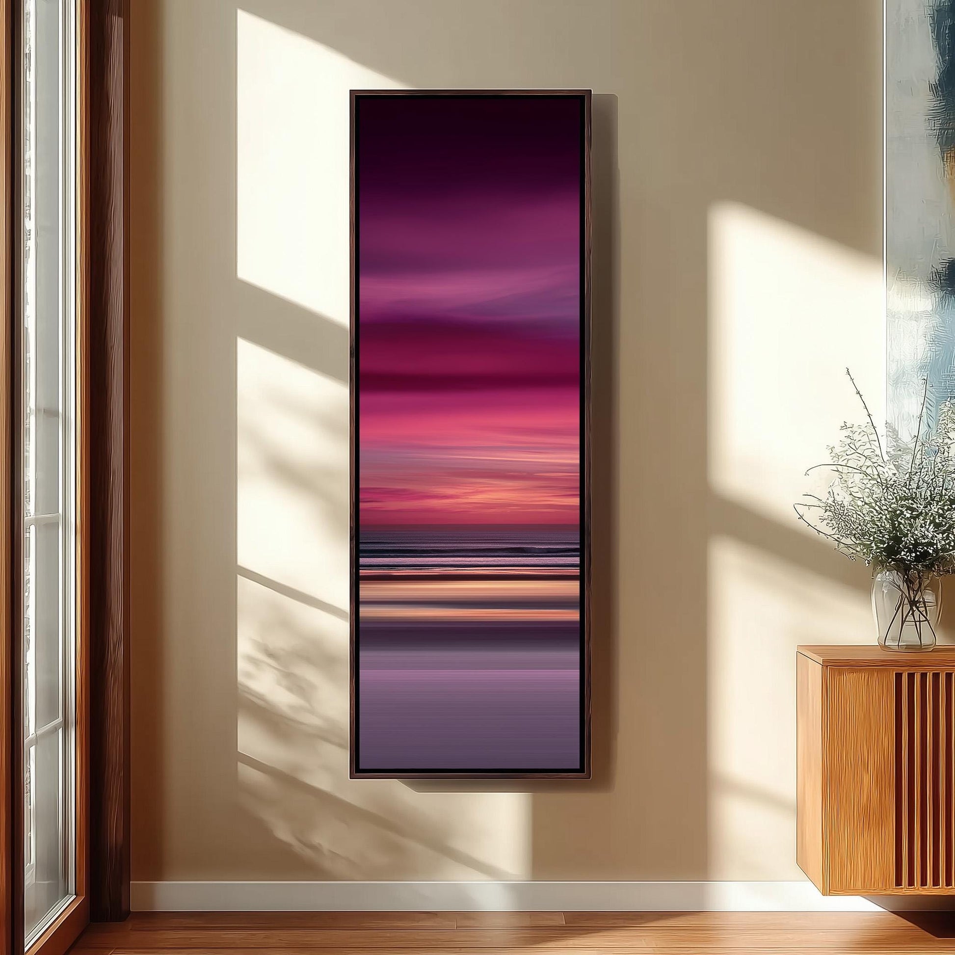 a large, rectangular painting hanging on a wall in a room with a wooden floor and a window.