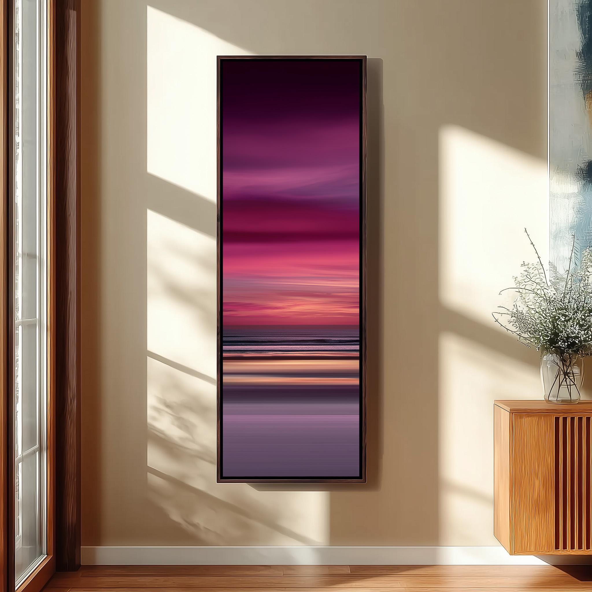 a large, rectangular painting hanging on a wall in a room with a wooden floor and a window.