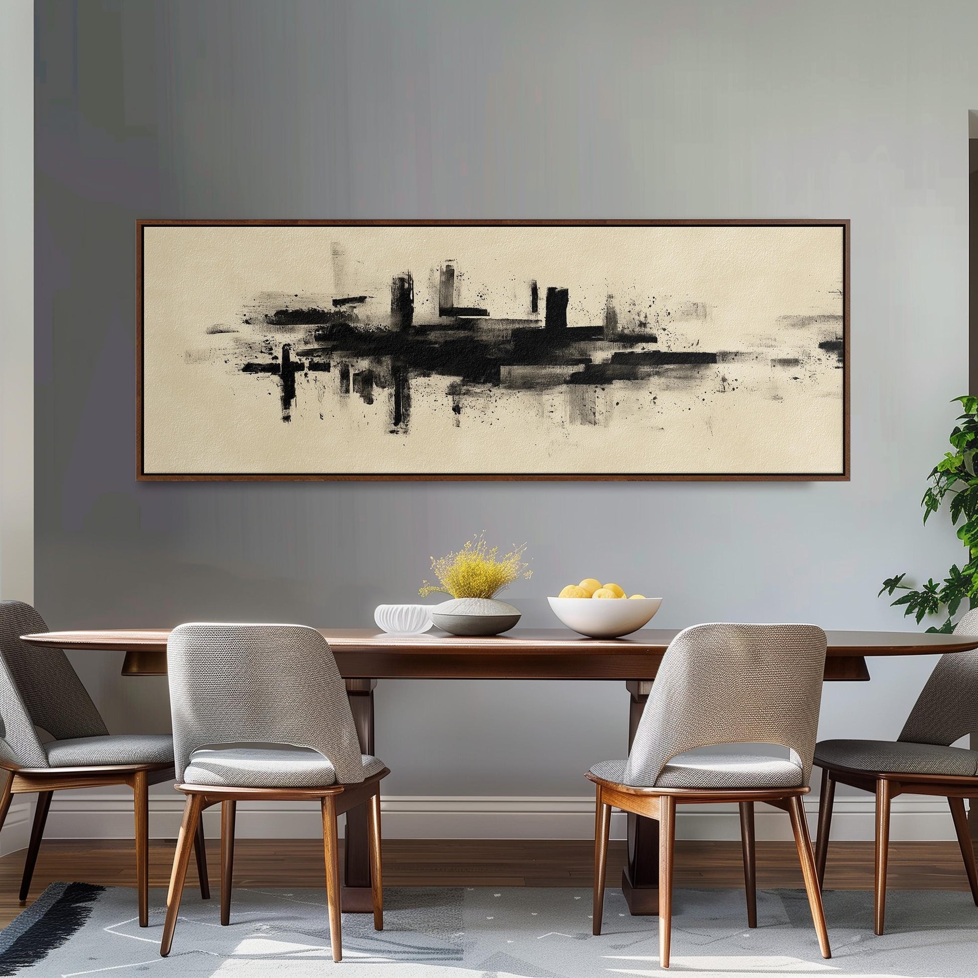 a dining room with a wooden table and four chairs. Above the table, there is a large abstract painting depicting a cityscape. The table is set with a bowl of fruit and a vase of flowers, creating a cozy and inviting atmosphere.