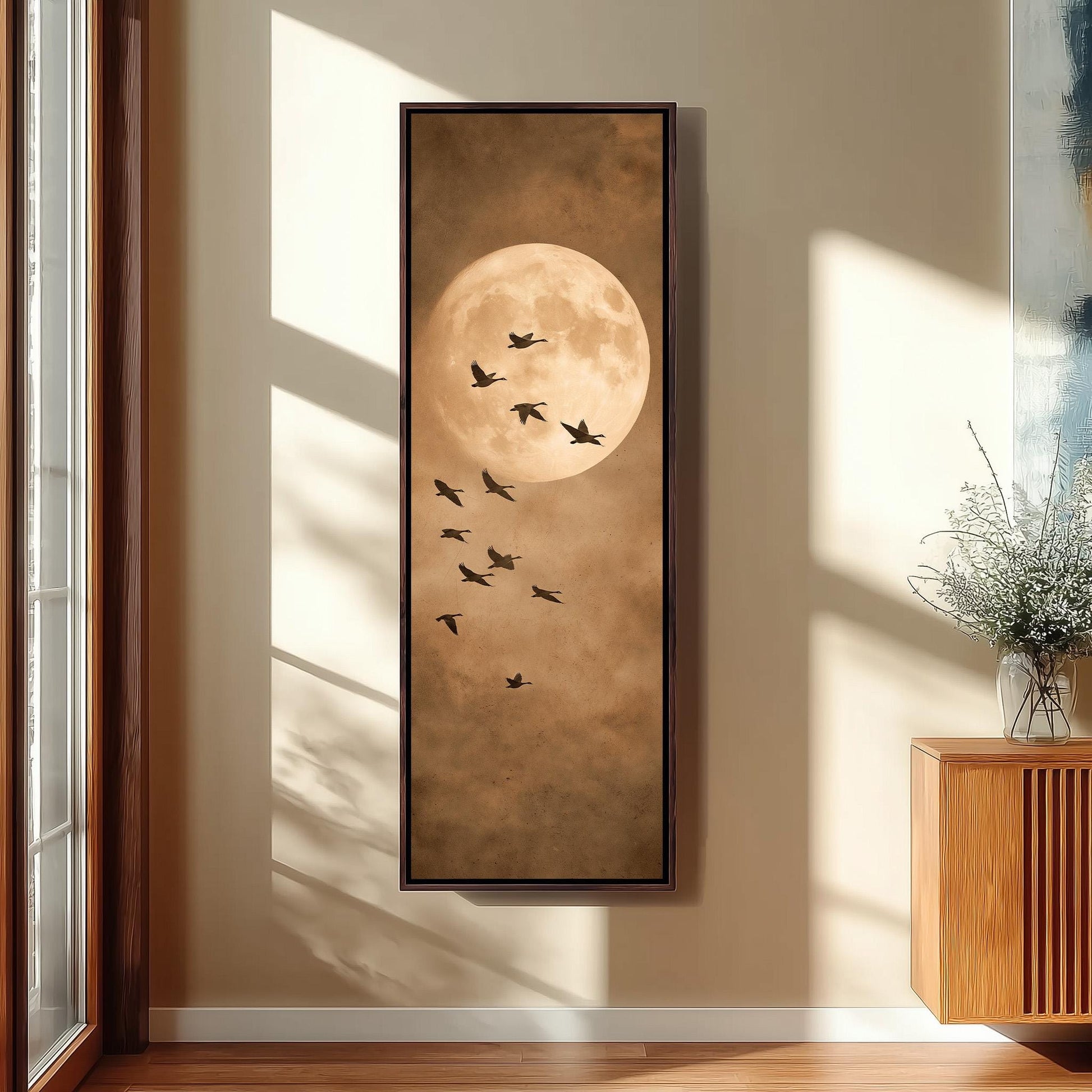 a large framed painting of a flock of birds flying against a backdrop of a full moon.
