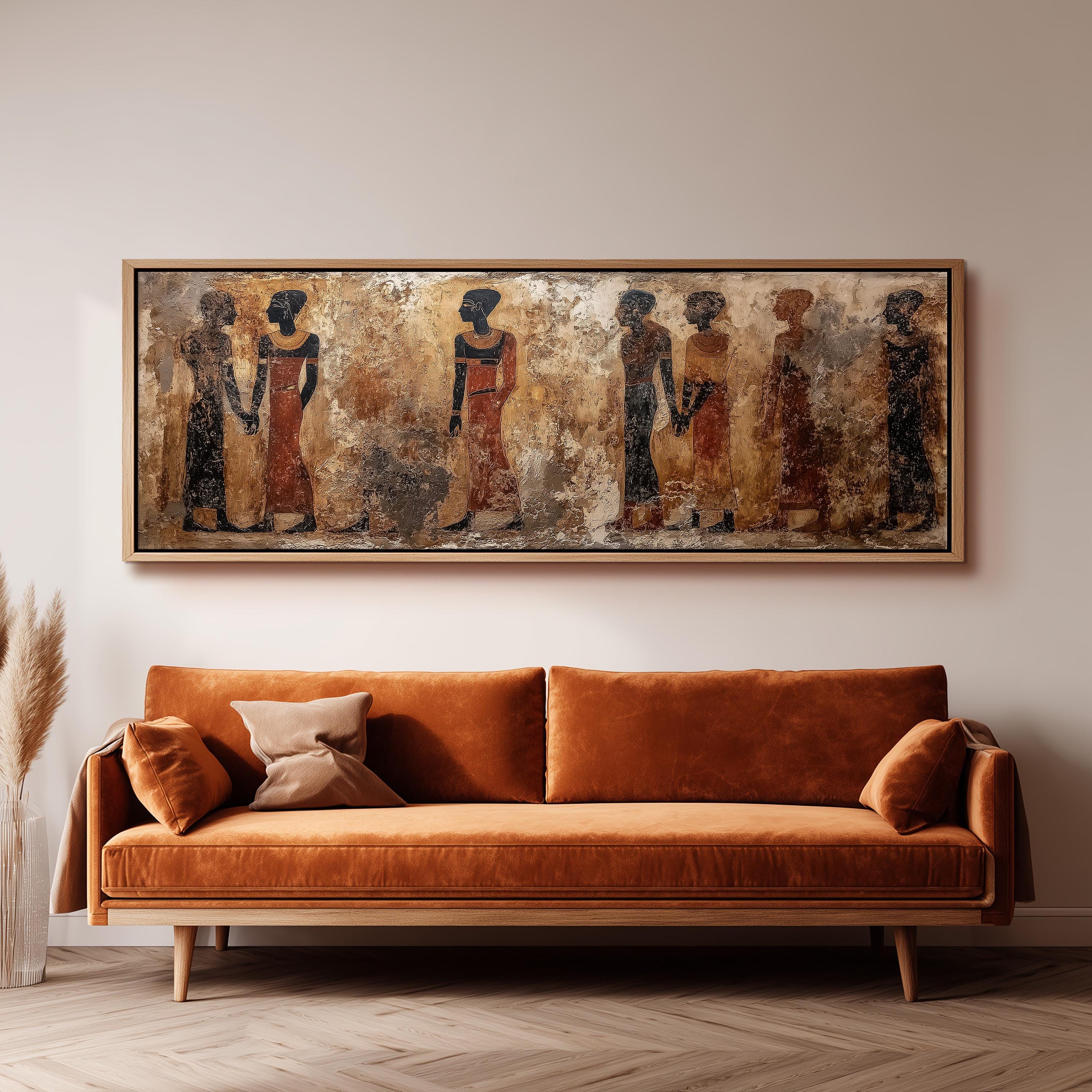 a large, framed painting of ancient Egyptian figures hanging on a wall above a brown sofa in a living room setting.
