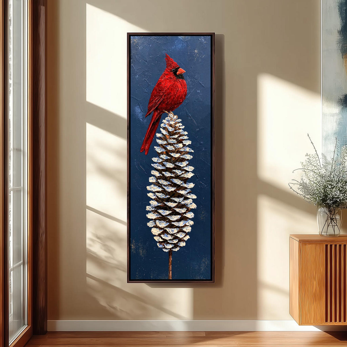 Red cardinal perched on a snowy pinecone long vertical canvas print in a sunlit living space