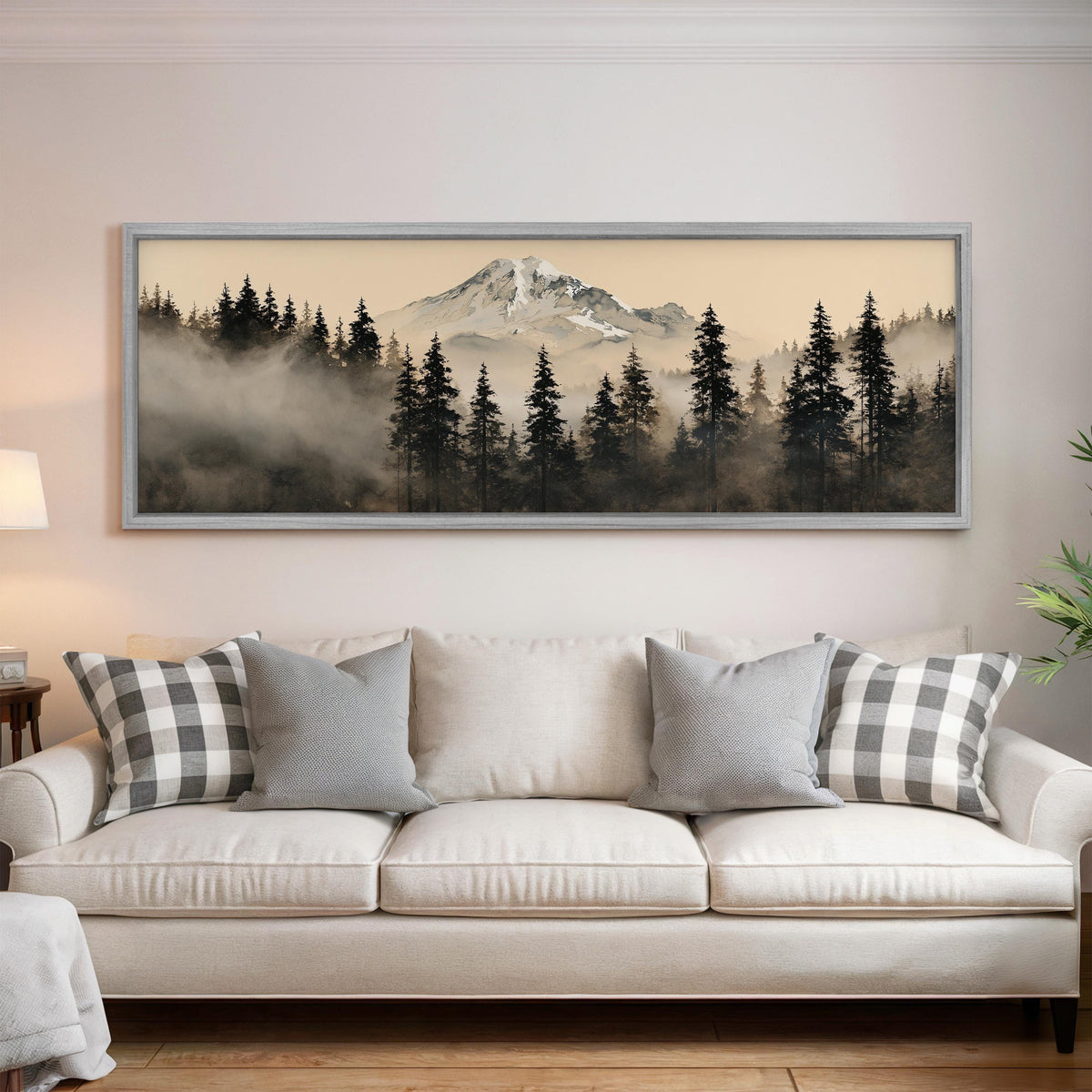 Foggy pine forest below a snowy mountain panoramic canvas print above a white sofa in a bright living room