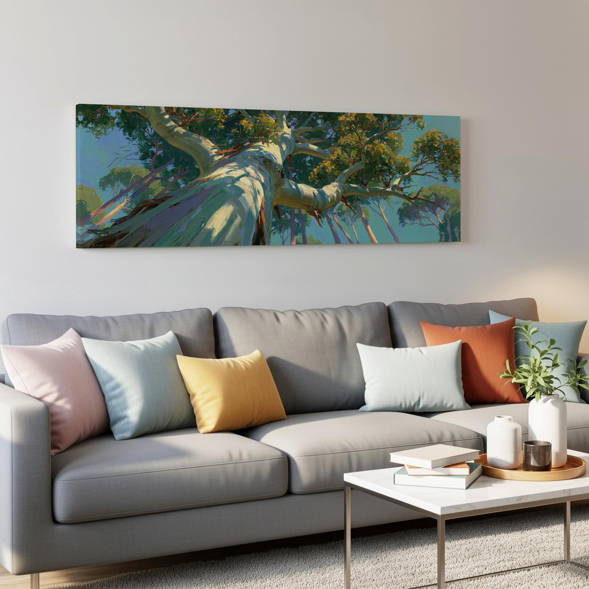 Eucalyptus canopy against a blue sky panoramic canvas print above a grey sofa in a living room