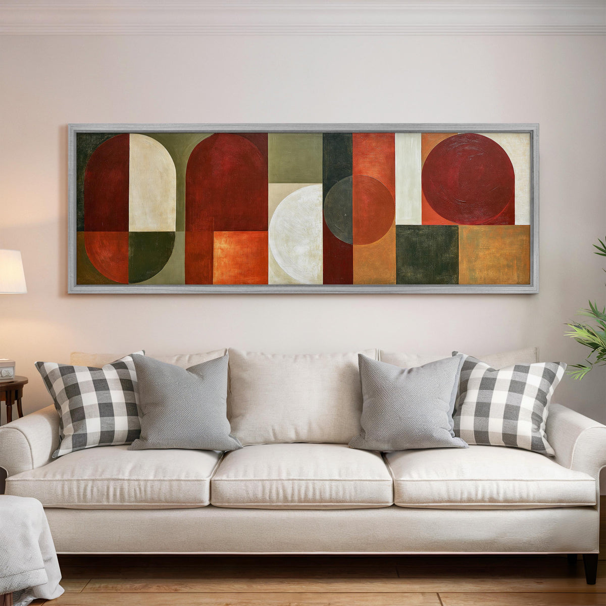 Maroon and olive geometric arches panoramic canvas print above a white sofa in a bright living room