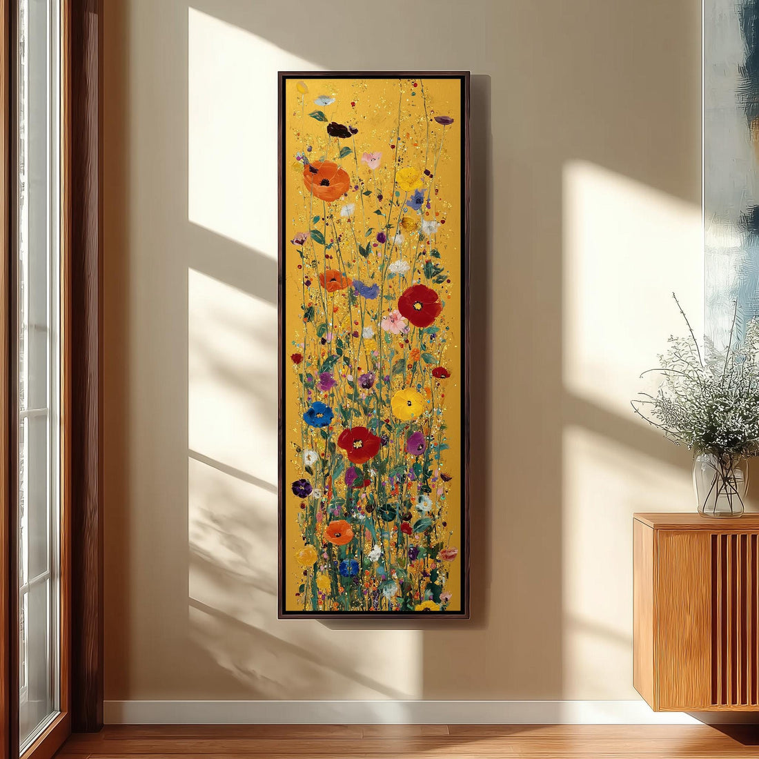 a large, colorful painting of flowers hanging on a wall in a room with a wooden chair and a small table.