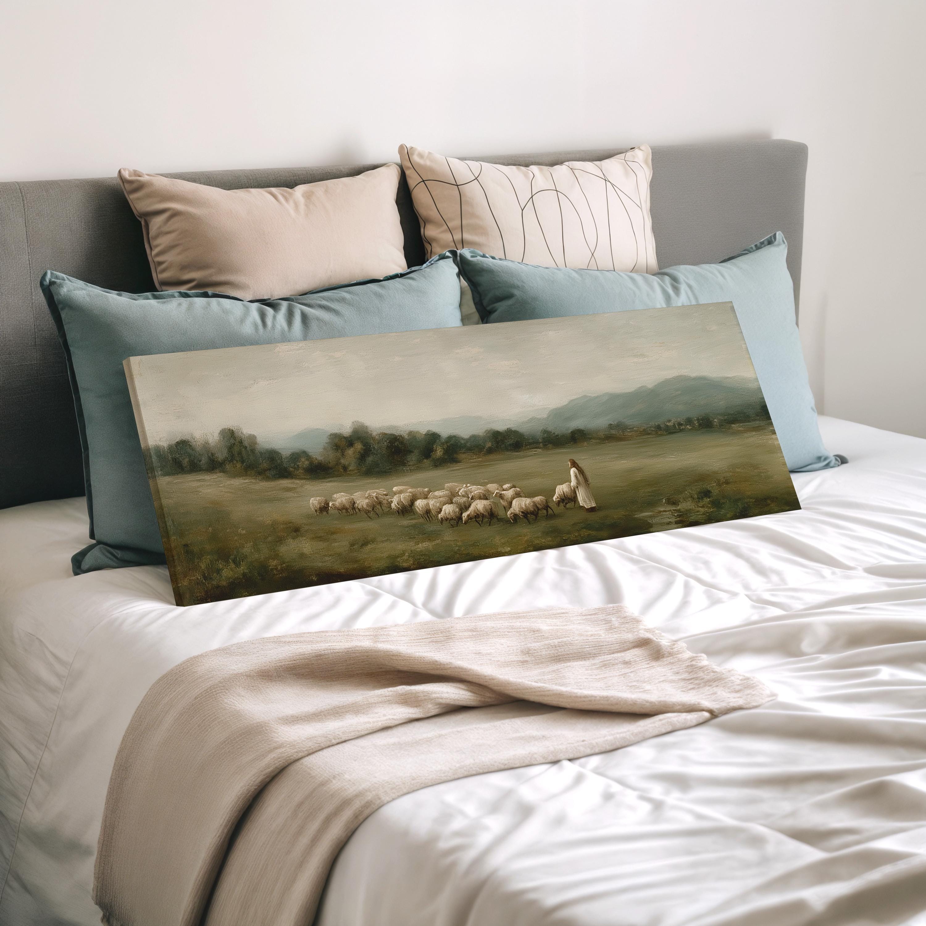 a large painting of a pastoral scene with a shepherd tending to his flock, displayed on a bed with pillows.