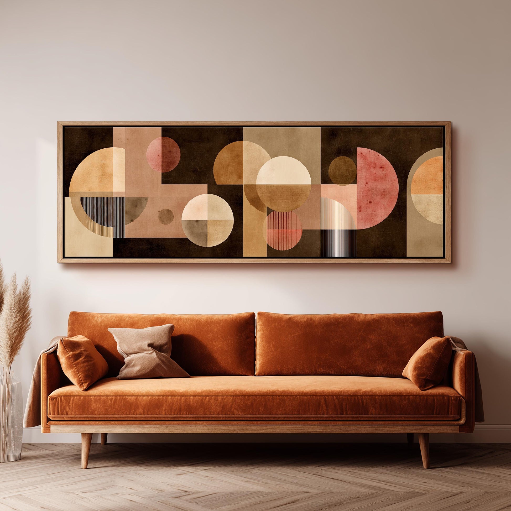 a large abstract painting hanging on a wall above a brown sofa with two pillows.