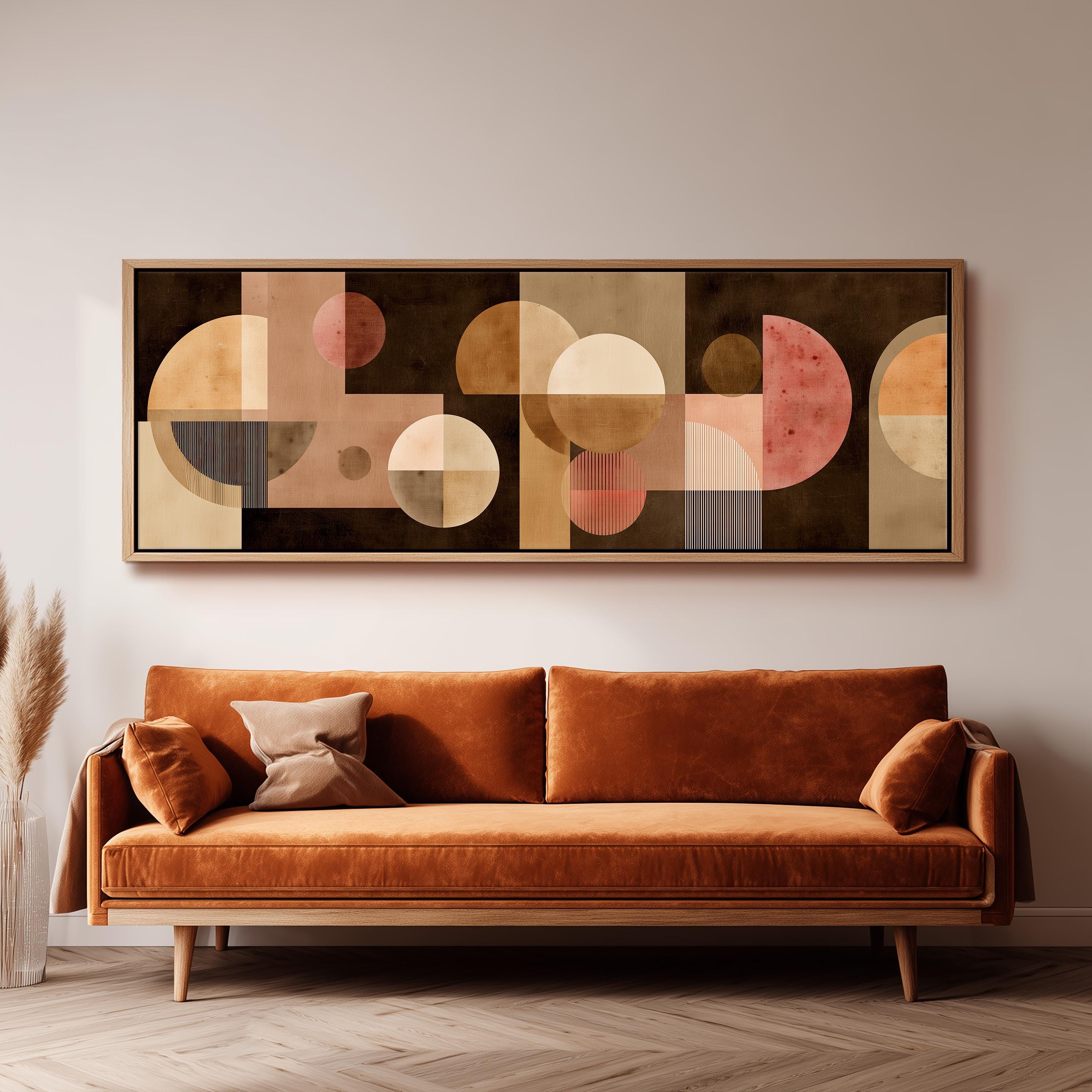 a large abstract painting hanging on a wall above a brown sofa with two pillows.