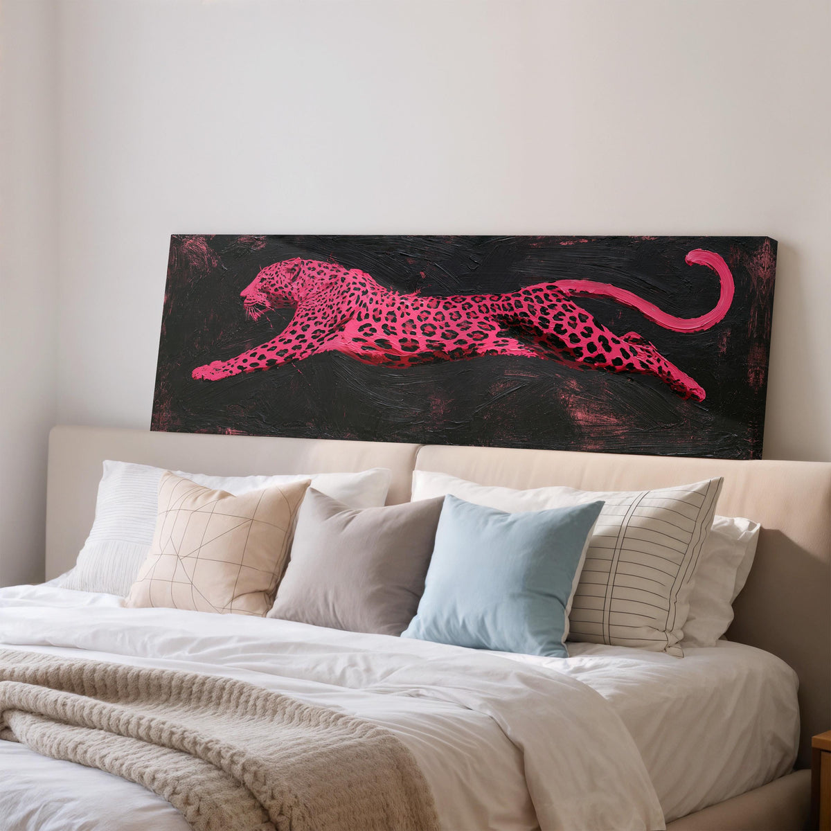 Pink leaping leopard wide panoramic canvas print above a bed in a bedroom