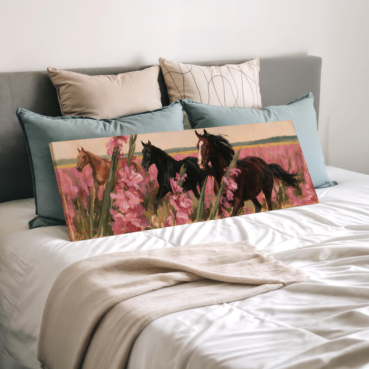 Horses running through pink gladiolus wide panoramic canvas print laid on a bed to show its size