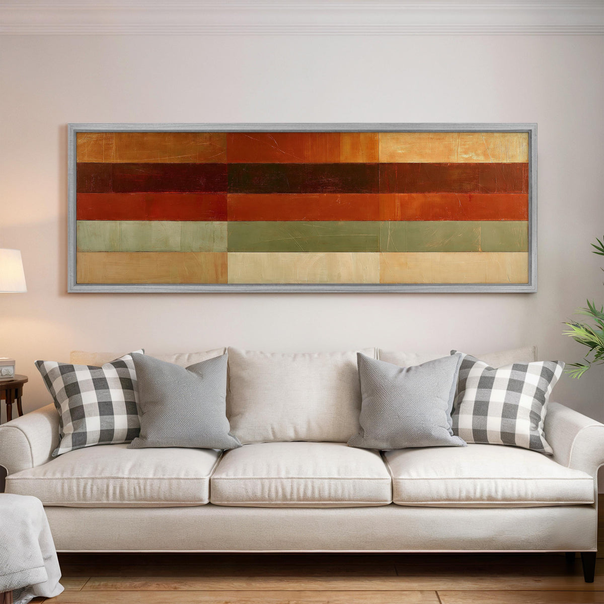 Amber, rust and sage horizontal color bands panoramic canvas print above a white sofa in a bright living room