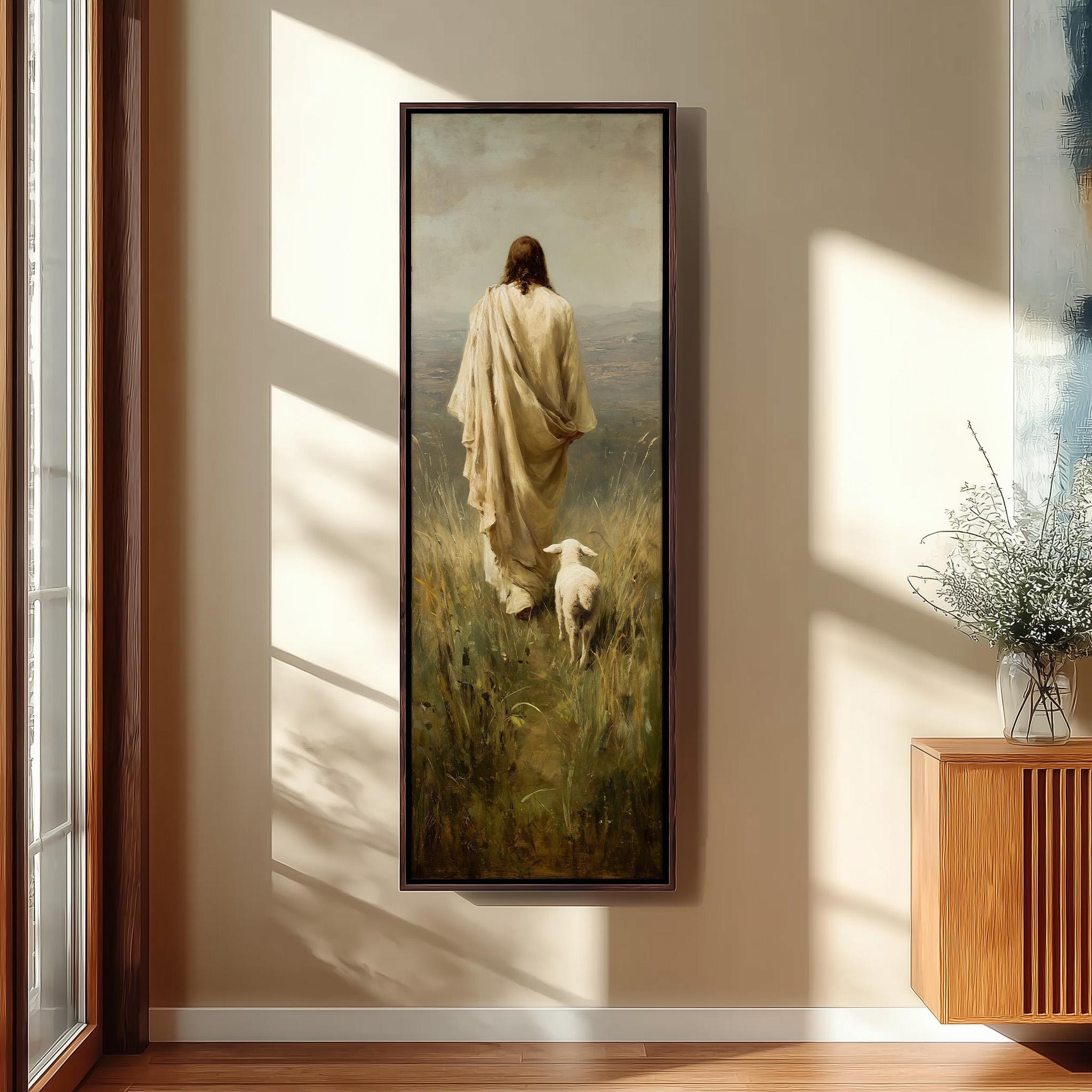 a person in a long robe walking through a field with a sheep, with a vase of flowers on a side table.