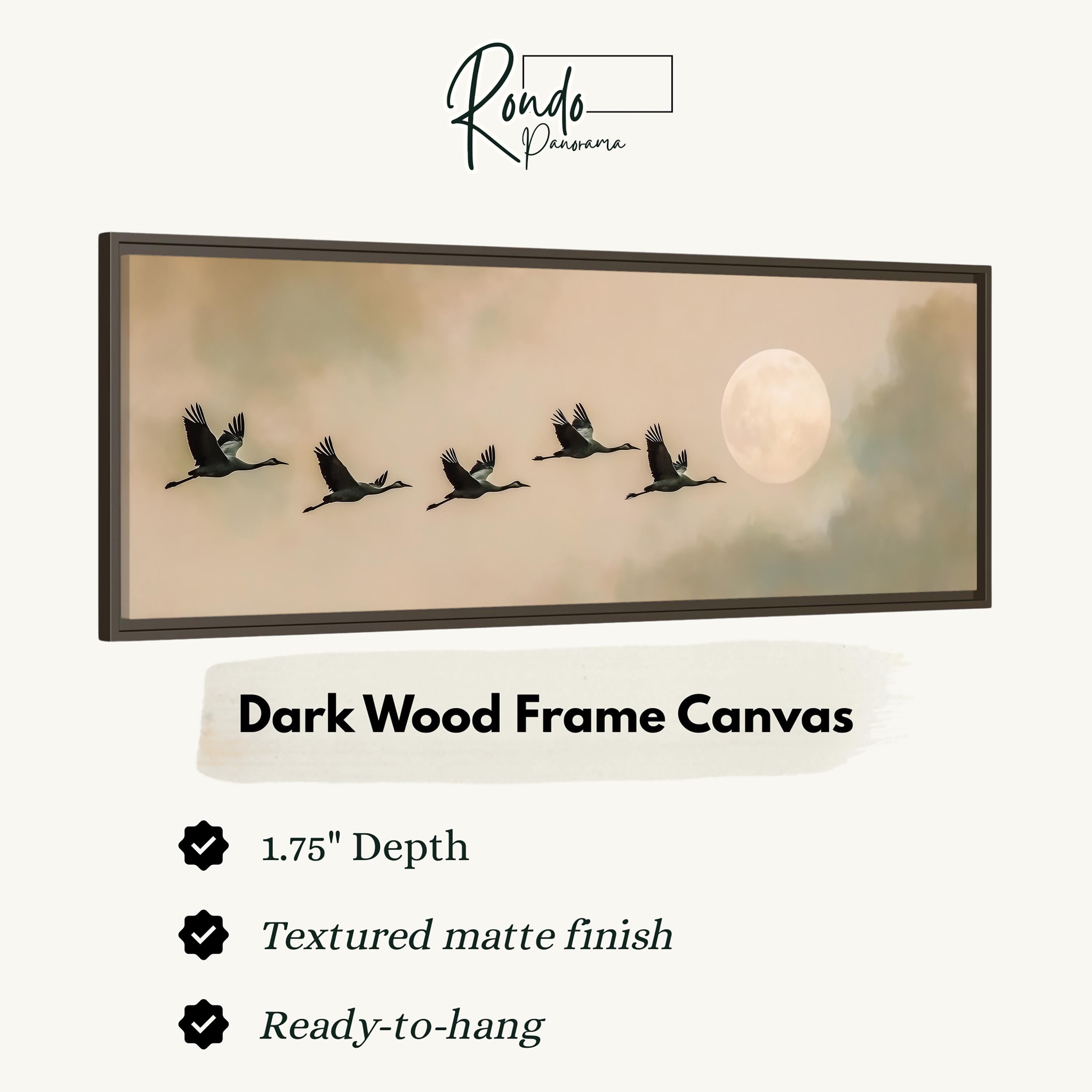 A framed artwork depicting a flock of birds flying in formation against a backdrop of a full moon and a cloudy sky.