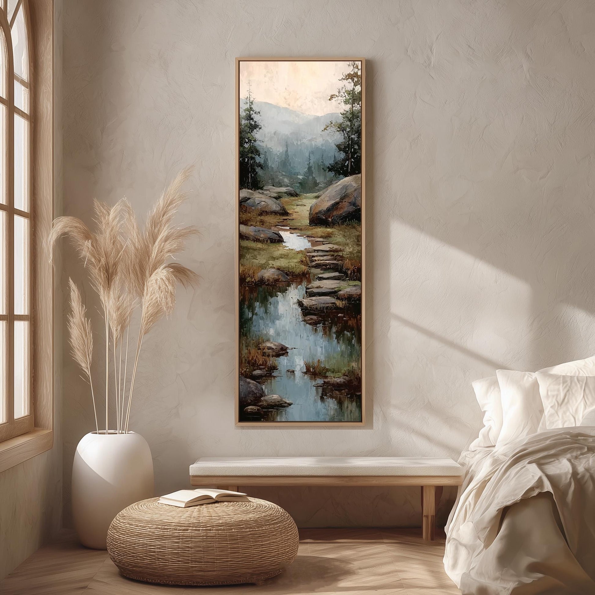 a serene bedroom scene with a large painting of a mountain landscape hanging on the wall, a white bench, a woven ottoman, and a window with a plant.