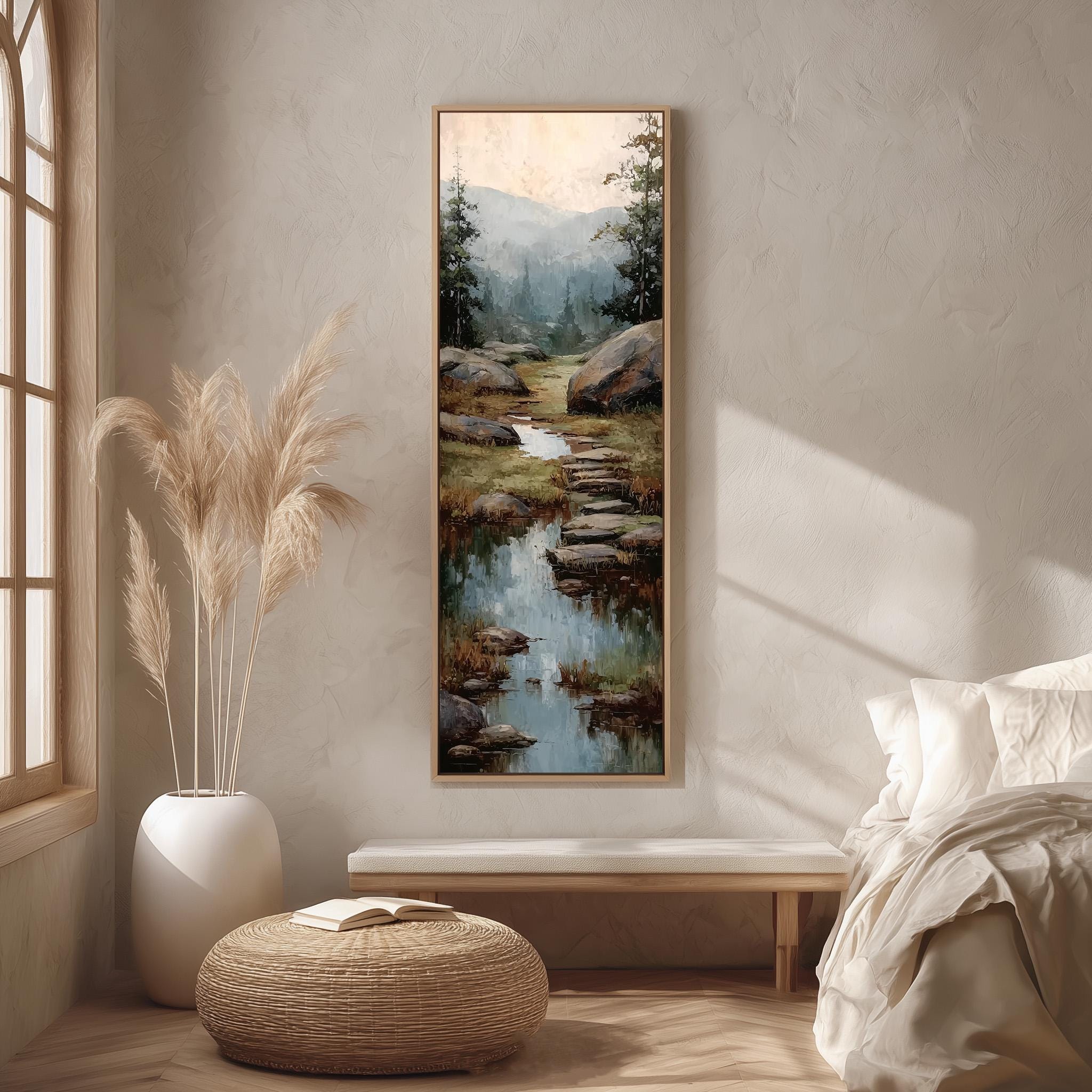 a serene bedroom scene with a large painting of a mountain landscape hanging on the wall, a white bench, a woven ottoman, and a window with a plant.