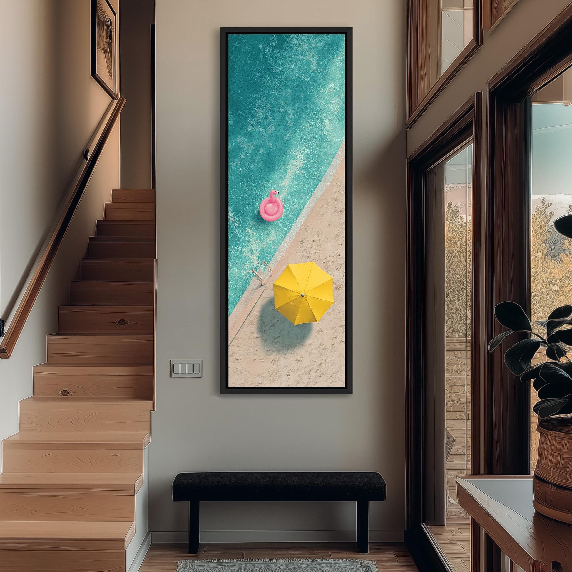 a large framed artwork depicting a beach scene with a swimming pool, a yellow umbrella, and a pink float, hanging on a wall in a hallway.