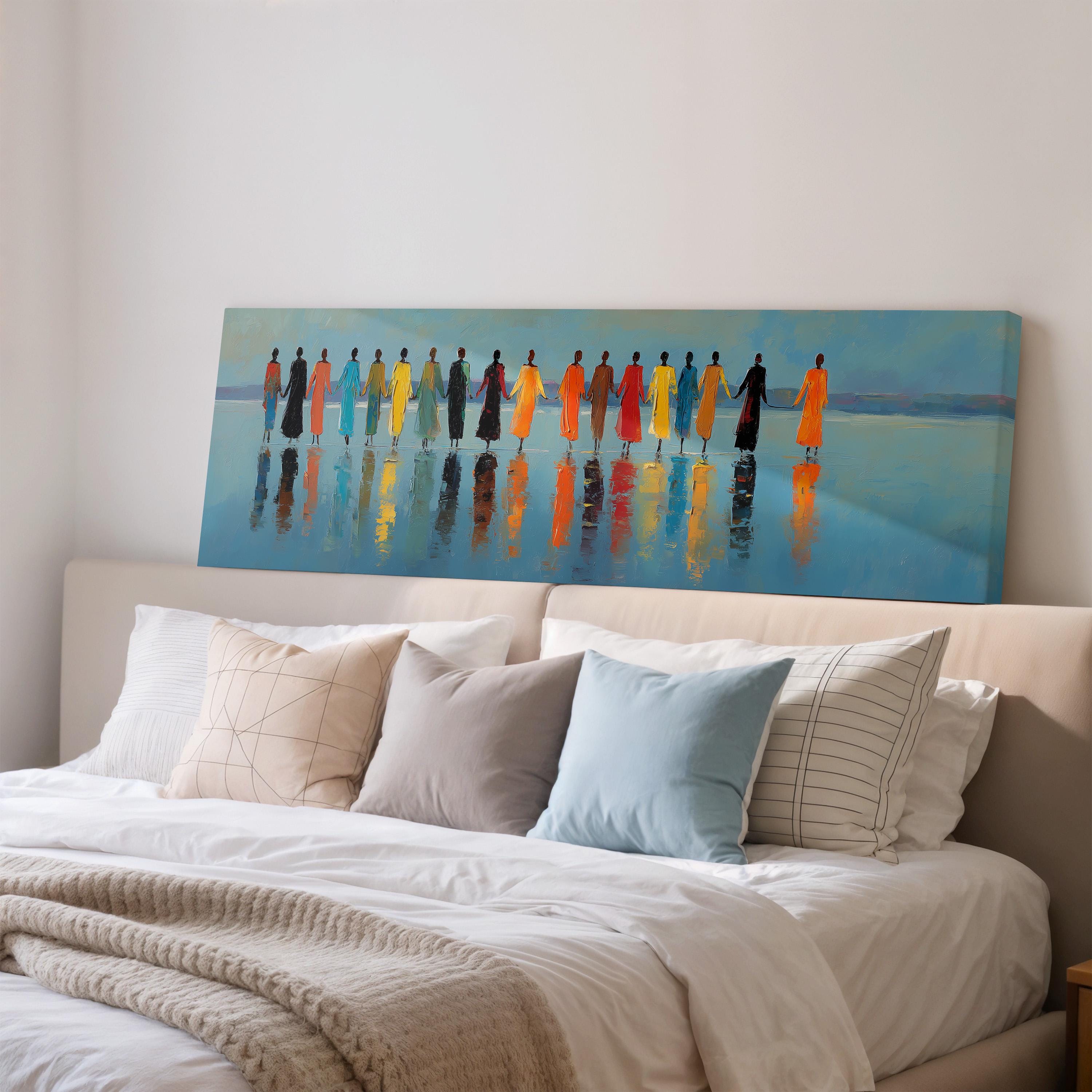 a large painting of a group of people standing in a line, with their reflections visible in the water below. The painting is displayed on a wall above a bed with white pillows and a gray blanket.