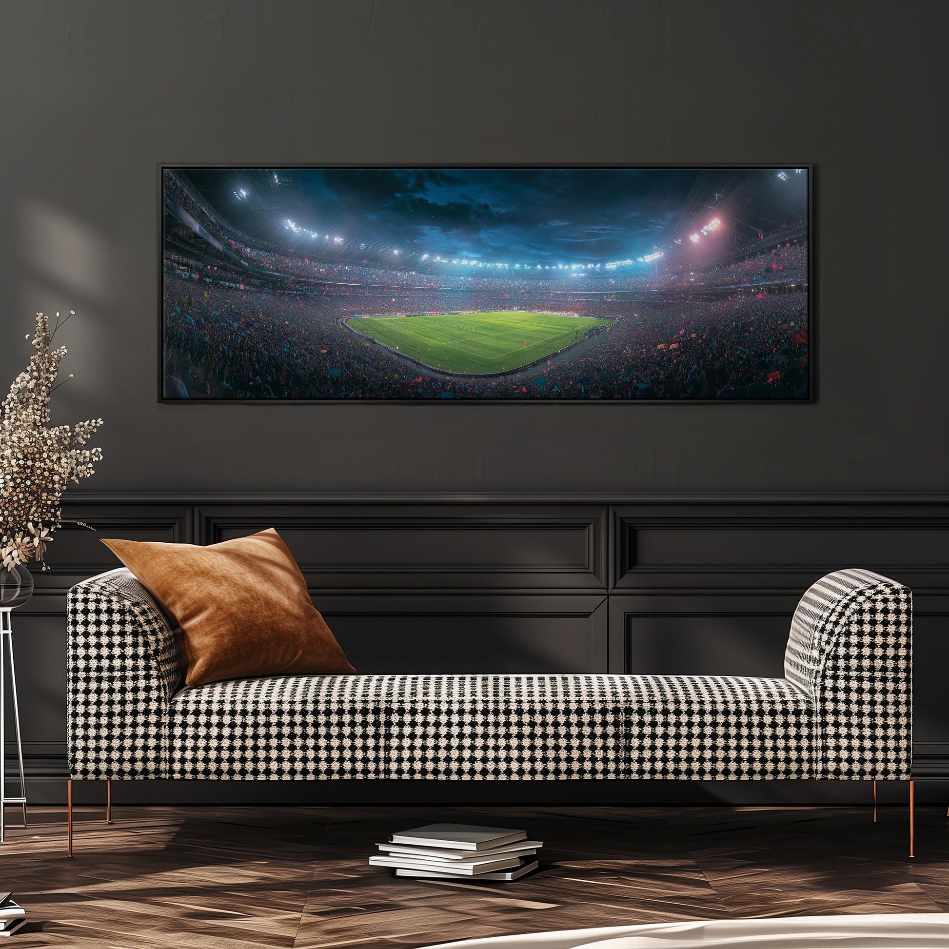 a large, colorful painting of a stadium with a crowd of people, hanging on a wall above a black and white checkered sofa.