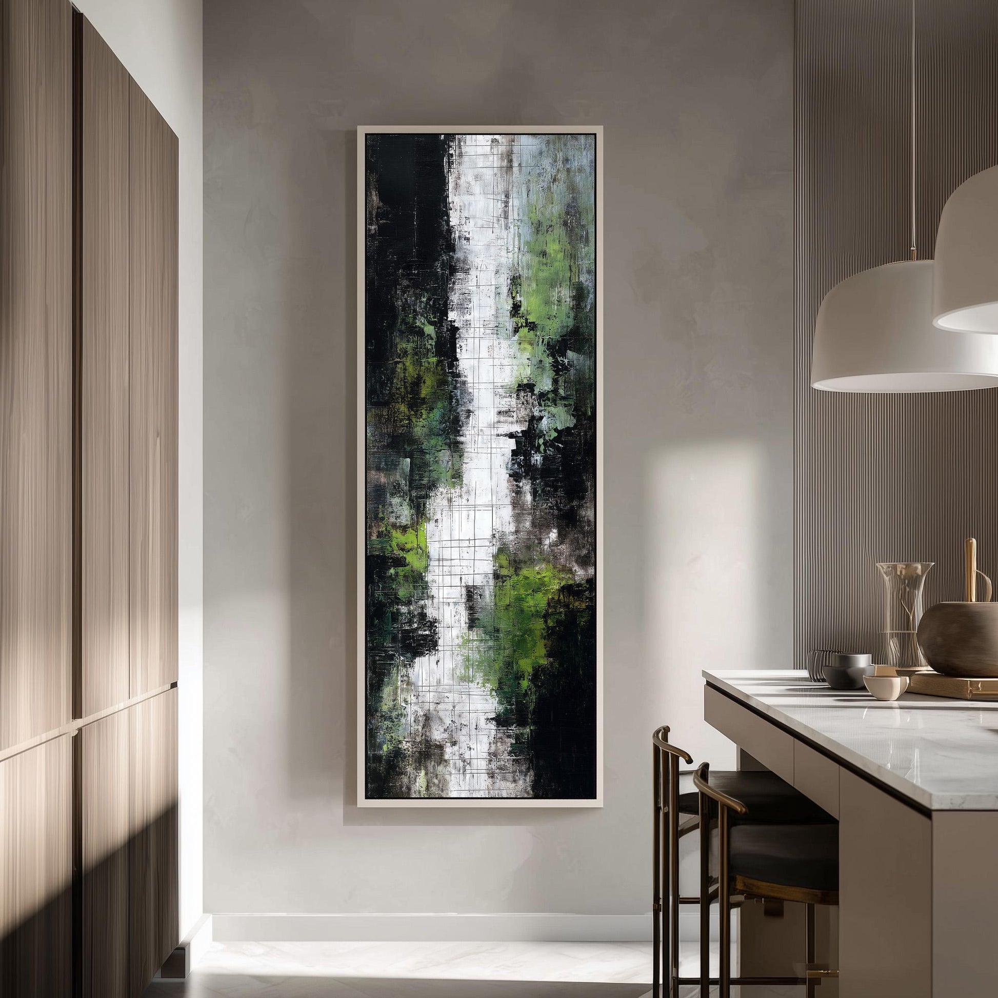 a modern kitchen with a large abstract painting hanging on the wall above a counter. The painting has a mix of green and black colors, creating a striking contrast. The kitchen is well-lit, with a pendant light hanging above the counter and a wooden cabinet visible in the background.