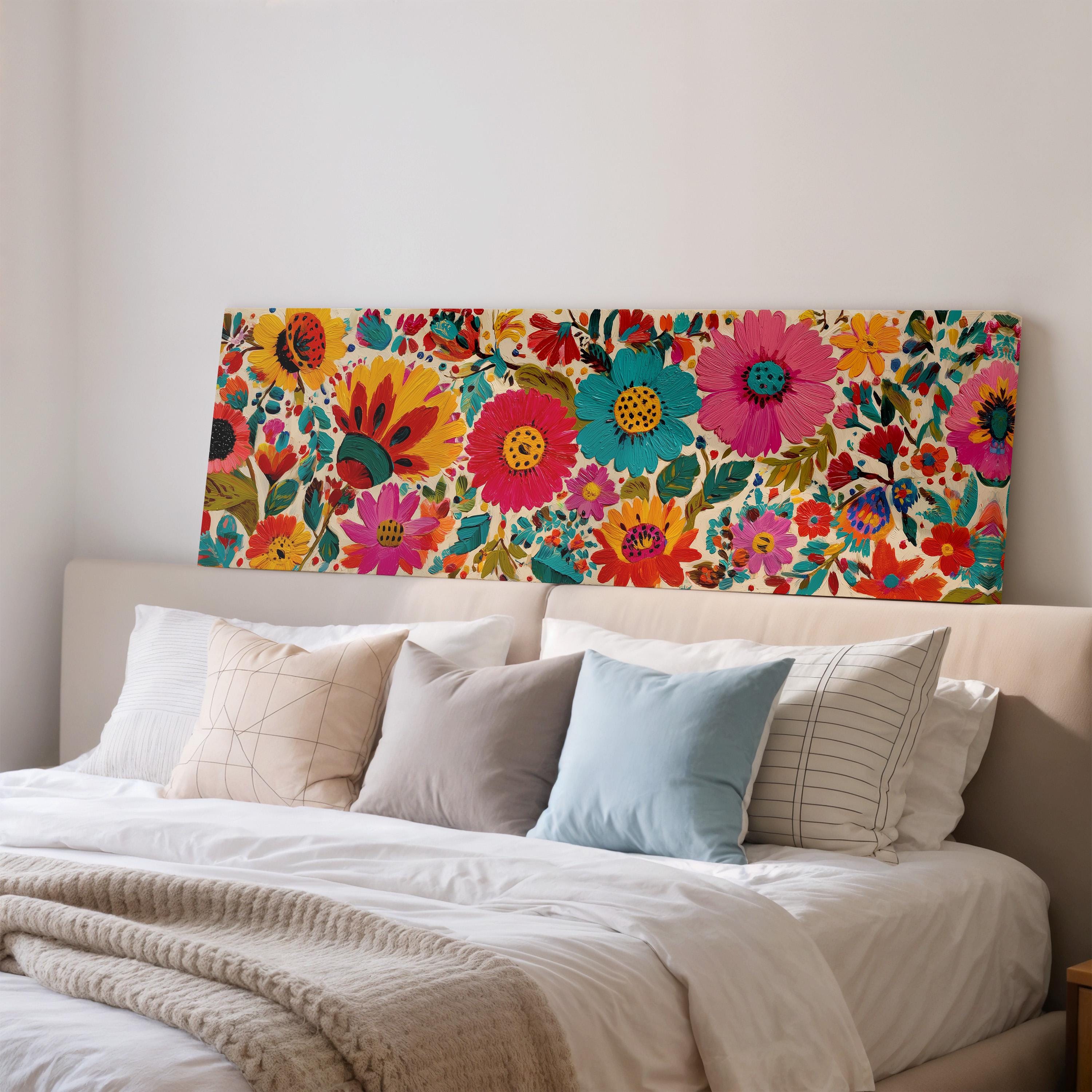 a bedroom with a large floral print on the wall behind a bed, which is adorned with a variety of colorful pillows.