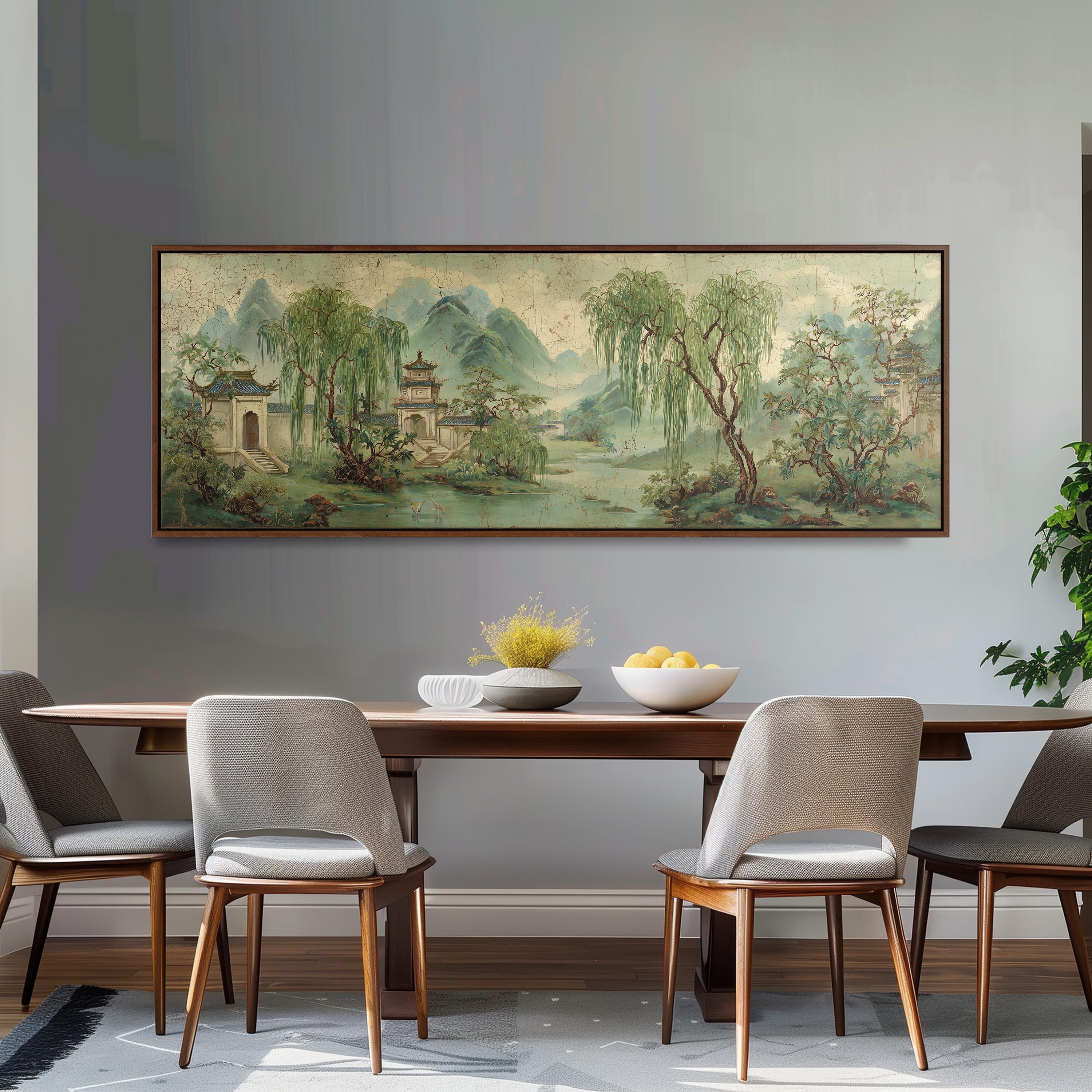 a dining room with a large painting of a serene landscape hanging on the wall above a wooden dining table with four chairs. The painting depicts a tranquil scene with a temple, trees, and a river, creating a peaceful atmosphere.