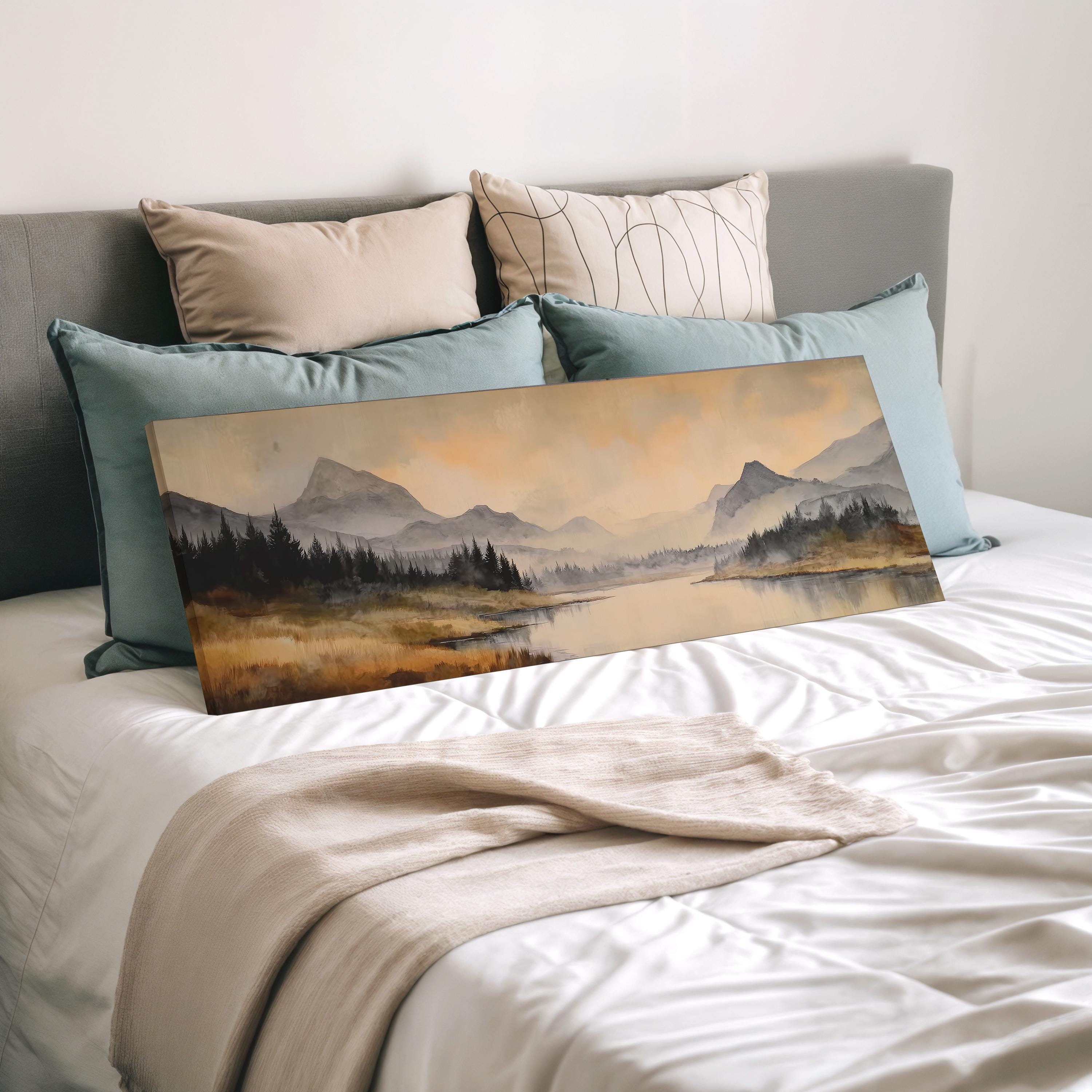 a bedroom with a large landscape painting propped up on a bed, featuring a serene mountain scene with a lake and trees.