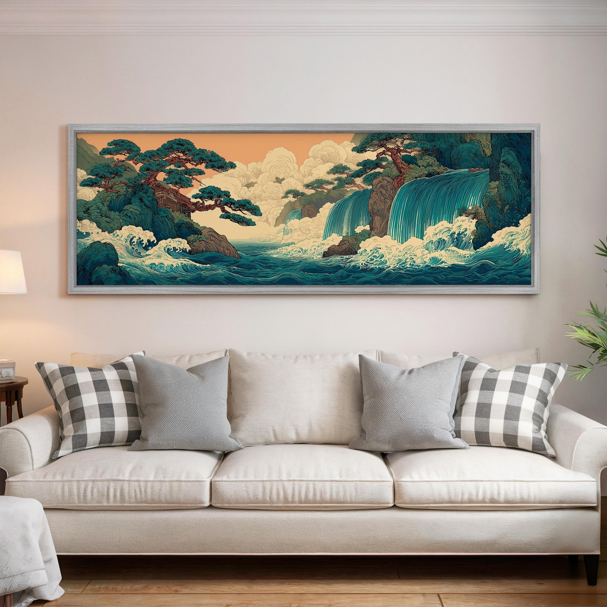 a large, framed painting of a serene landscape with a waterfall and trees hanging on a wall above a white couch with patterned throw pillows.