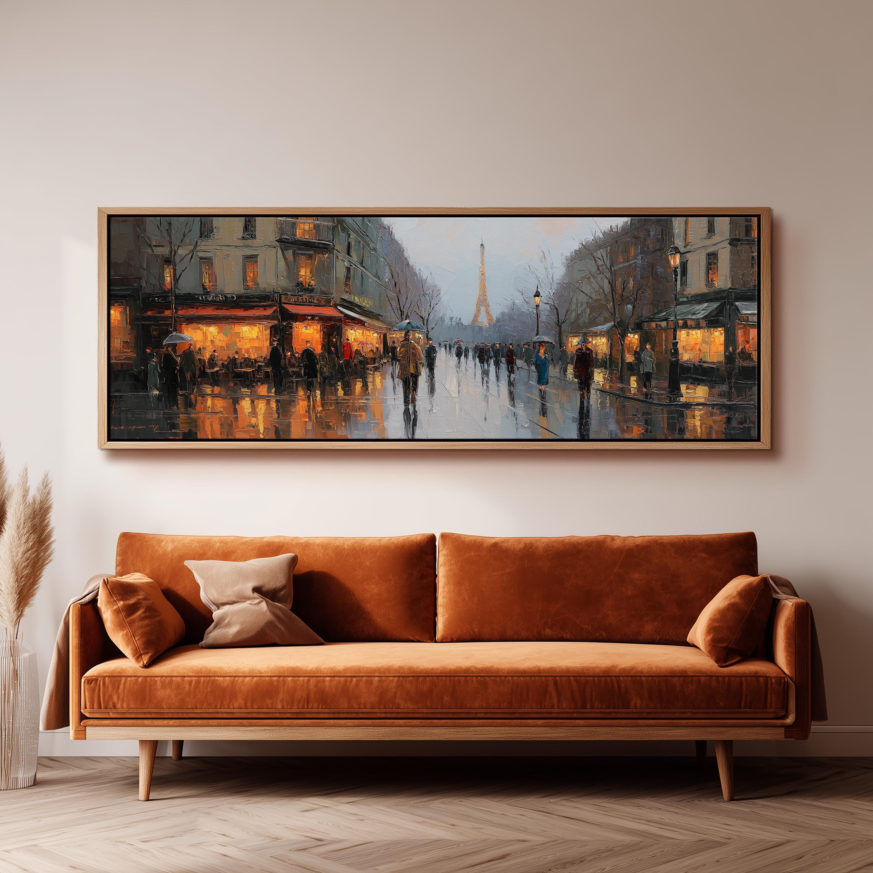 a large, framed painting of a rainy Paris street scene with people walking on the wet pavement and illuminated buildings in the background.