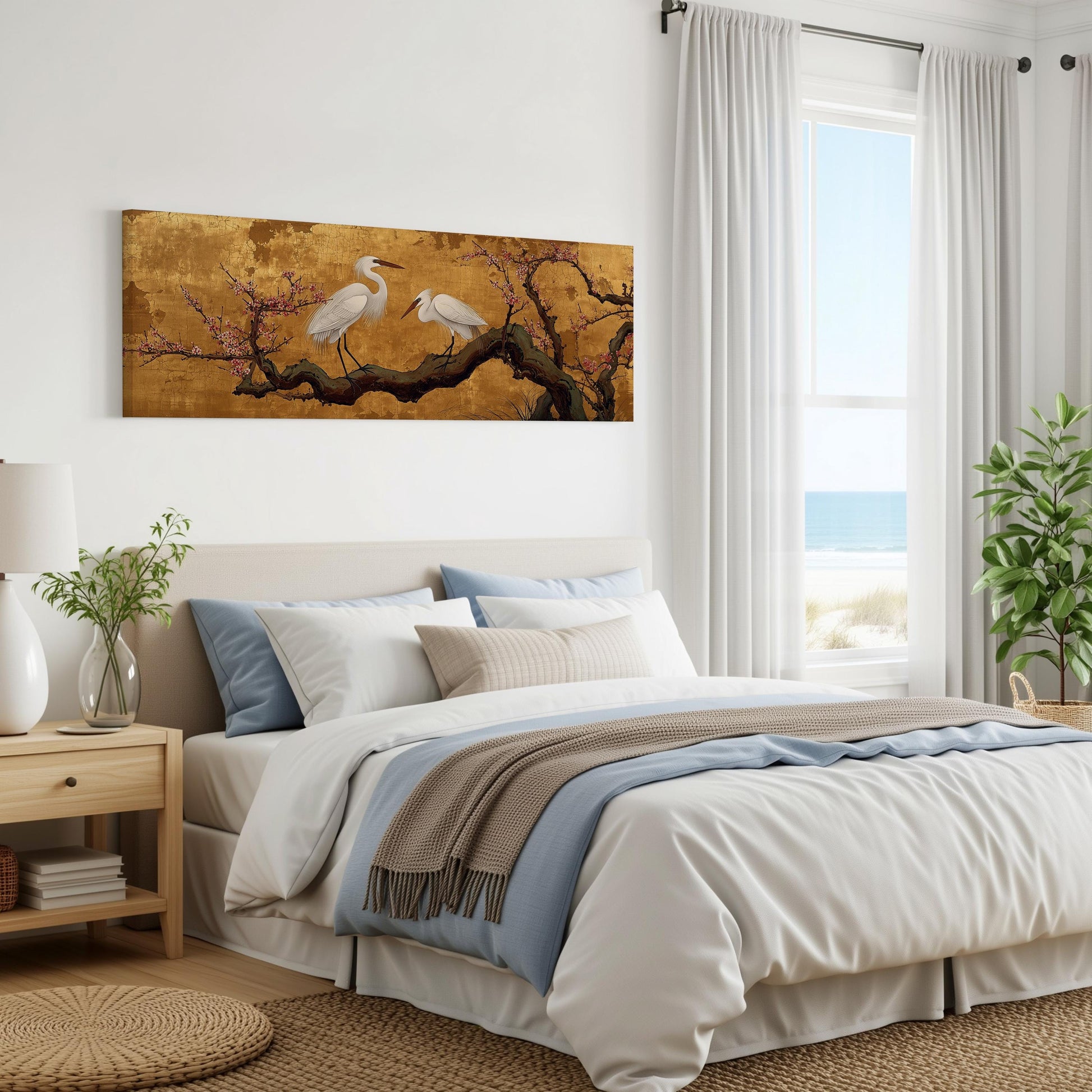 a serene bedroom scene with a large bed, a painting of two white birds perched on a branch, and a window overlooking the ocean.