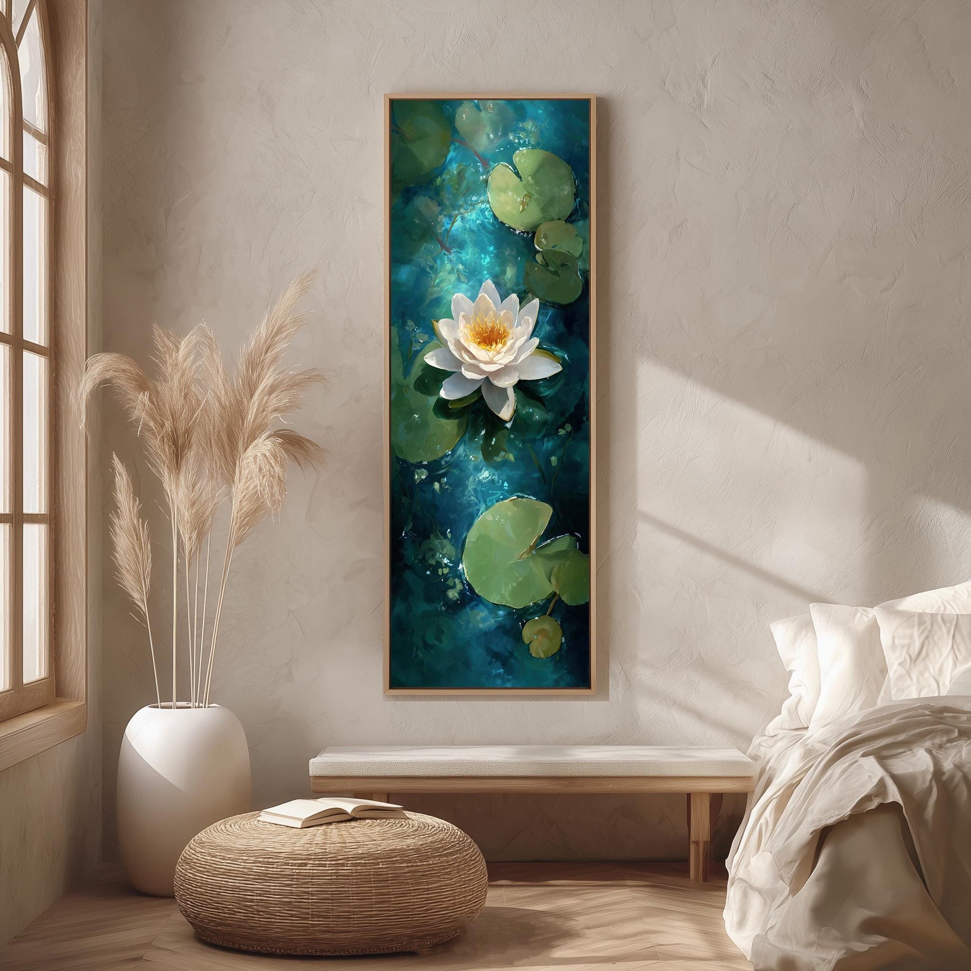 a serene indoor setting with a large painting of a white lotus flower on a blue background hanging on the wall. The painting is framed in a wooden frame and is the focal point of the room. The room is decorated with a white bed, a wicker ottoman, and a potted plant, creating a calm and peaceful atmosphere.
